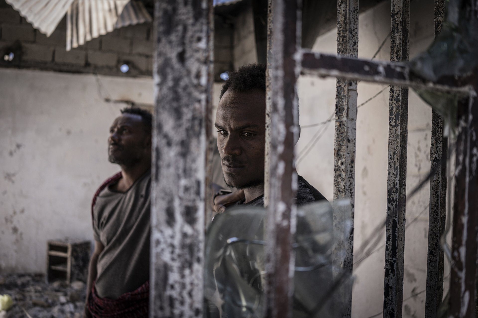 Men look at a burned warehouse, allegedly looted by pro-Tigray fighters in Shewa Robit, Amhara, Ethiopia. Pro-Tigray forces took Shewa Robit on 21 November 2021, and it was re-taken by government forces on 1 December. Afar militia groups had been collaborating closely with the Ethiopian military in fighting pro-Tigray forces.