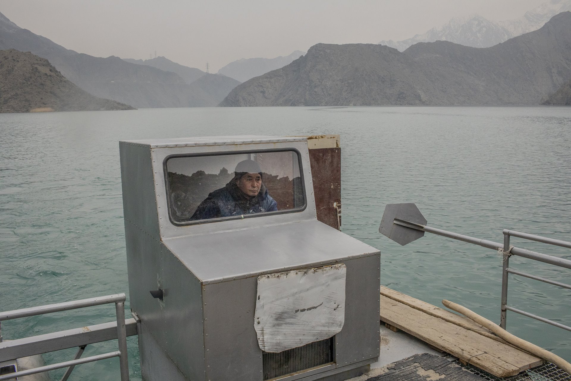 Sonunbek Kadyrov pilots his water taxi, serving the village of Kyzyl-Beyit, Kyrgyzstan. Local access to the main road was blocked by flooding during construction of the Kurpsayskaya Dam in the 1960s.