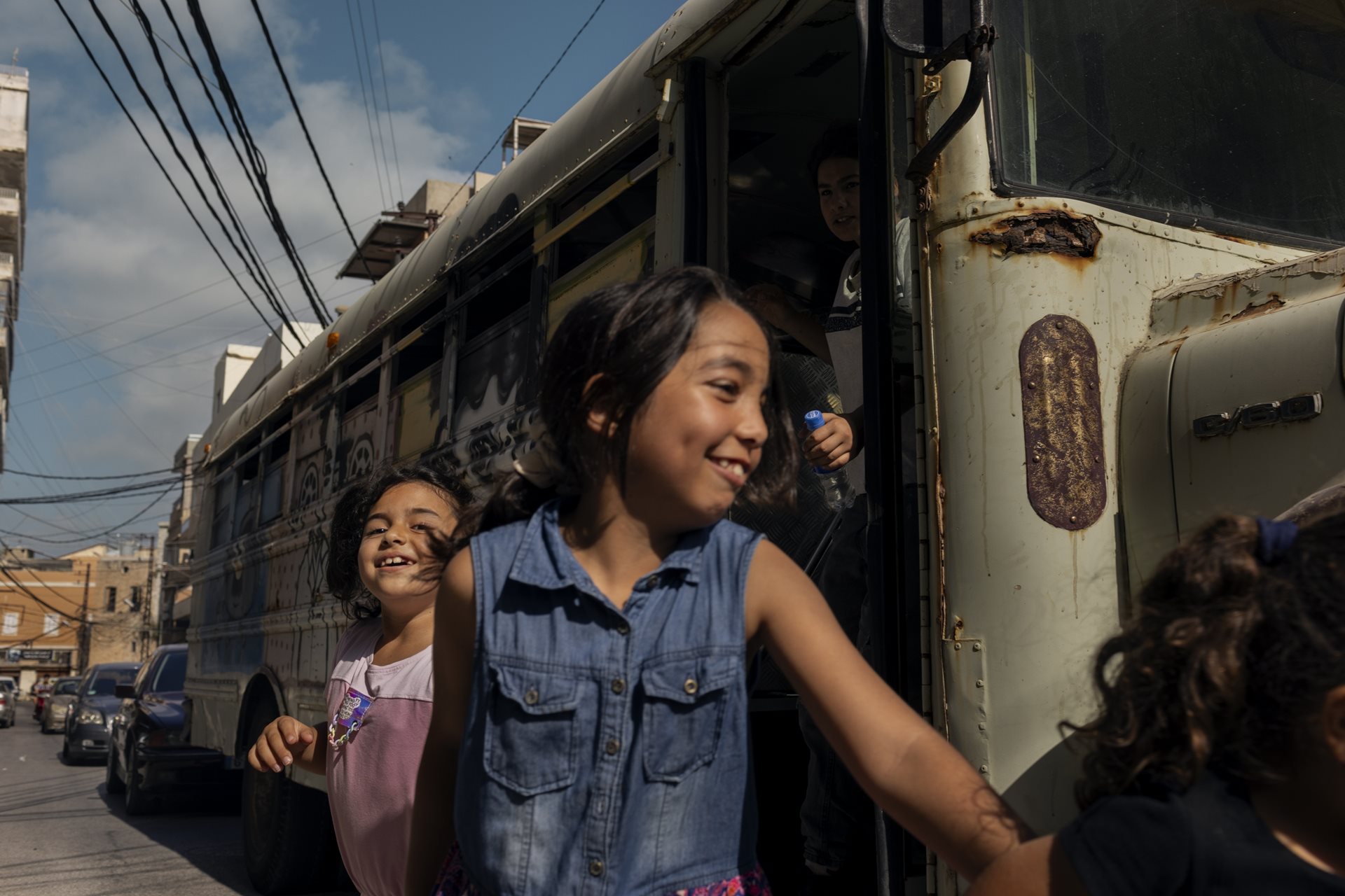 A displaced Lebanese child exits the Peace Art Bus outside the Lebanese National Theater to participate in artistic activities designed to alleviate stress. Tyre, Lebanon.