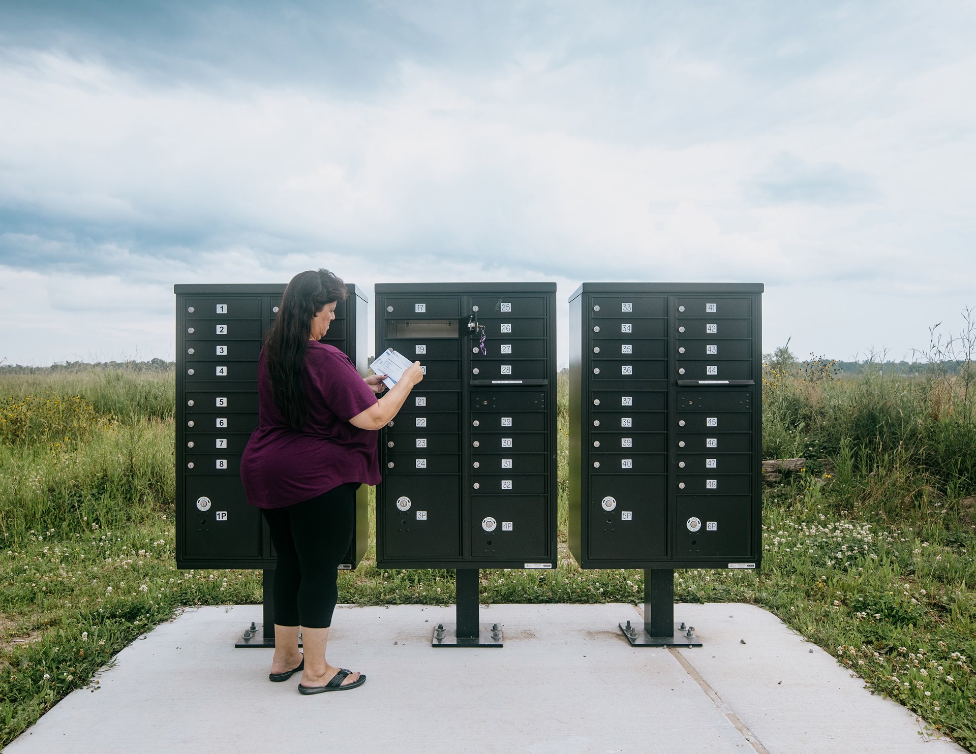 Sabrina Verdin, a native and former resident of Isle de Jean-Charles, picks up her mail in the new neighborhood of Gray where she now lives with her husband. Gray, Louisiana, United States.