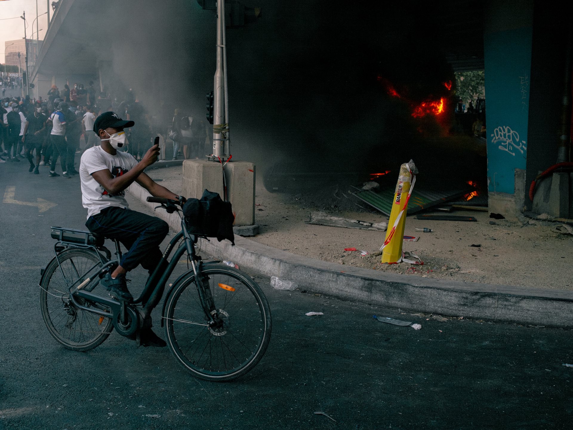 After setting fire to a bridge, demonstrators take photographs of themselves during a rally in Paris, France, against police violence called by Assa Traoré following the 2016 death of her brother Adama in gendarmerie custody. Some 20,000 people attended.