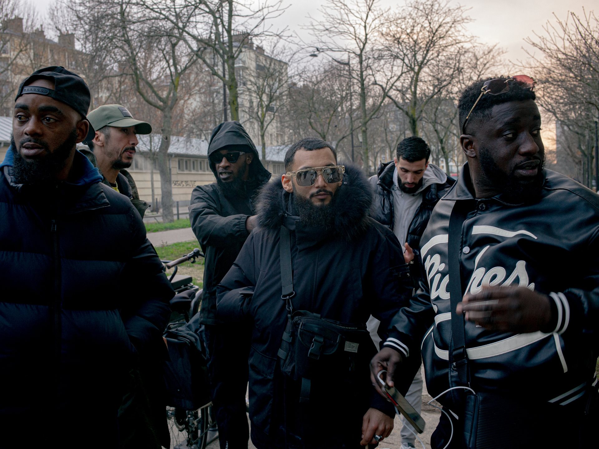 Zak (center), a resident of a working-class neighborhood, waits outside a gym in Paris, France, for the arrival of Russian fighters. He regularly participates in illegally organized fights.
