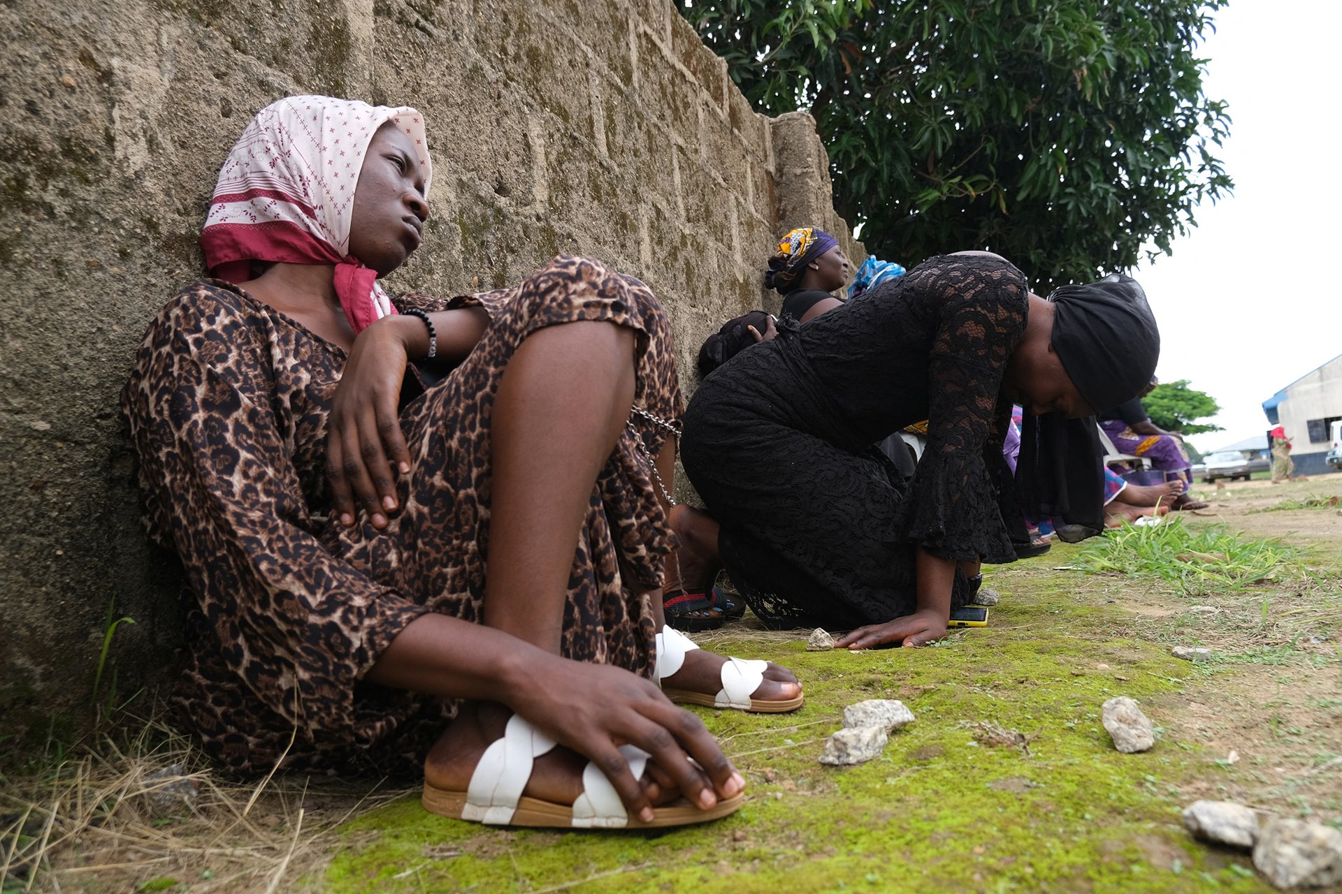 Parents of students abducted from the Bethel Baptist High School sit inside the school premises to pray for their return. Gunmen had kidnapped an estimated 140 students on 5 July, and taken them into the forest.