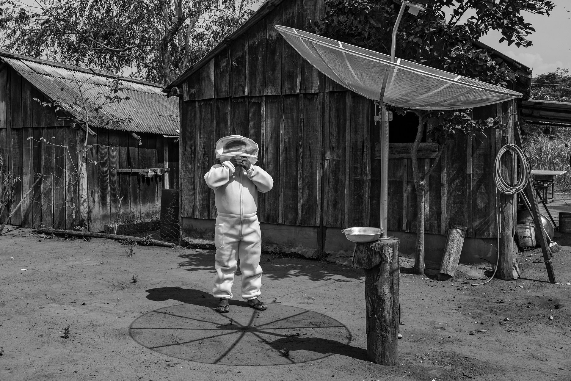 Paulo Marcos Tupxi, removes his beekeeper&#39;s outfit after collecting honey from his apiary in the Irántxe Indigenous Land, in Mato Grosso, in the Brazilian Amazon. Many members of his Manoki community have turned from traditional subsistence practices to planting soybeans.