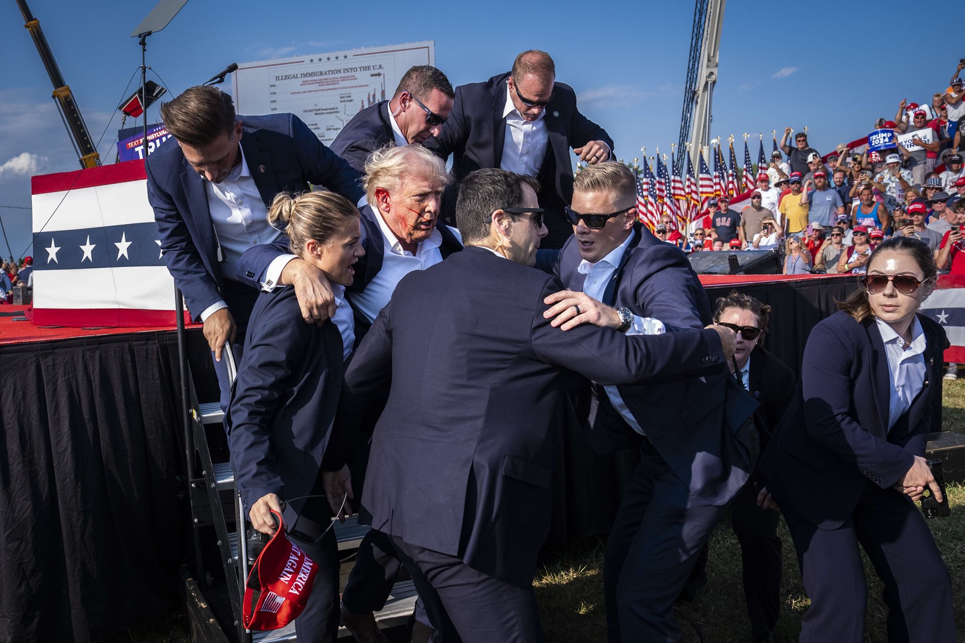 Members of the United States Secret Service help Republican presidential nominee Donald Trump off-stage moments after a bullet from an attempted assassin hit his ear during a campaign rally in Butler, Pennsylvania, United States.
