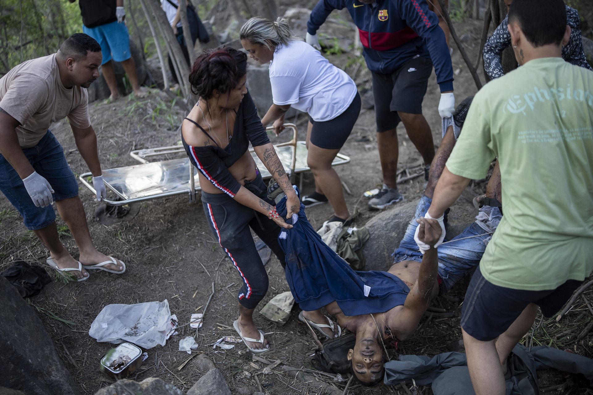 Residents carry a body out of the Vacaria forest, in Rio de Janeiro, Brazil. In the complete absence of state rescue or forensic teams, the community was forced to recover their own dead.