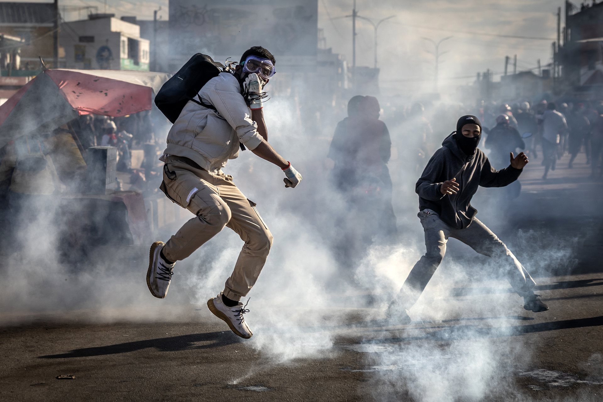 A protester jumps to avoid a tear gas canister during clashes with Malagasy security forces at a demonstration calling for the resignation of President Andry Rajoelina in Antananarivo, Madagascar.&nbsp;