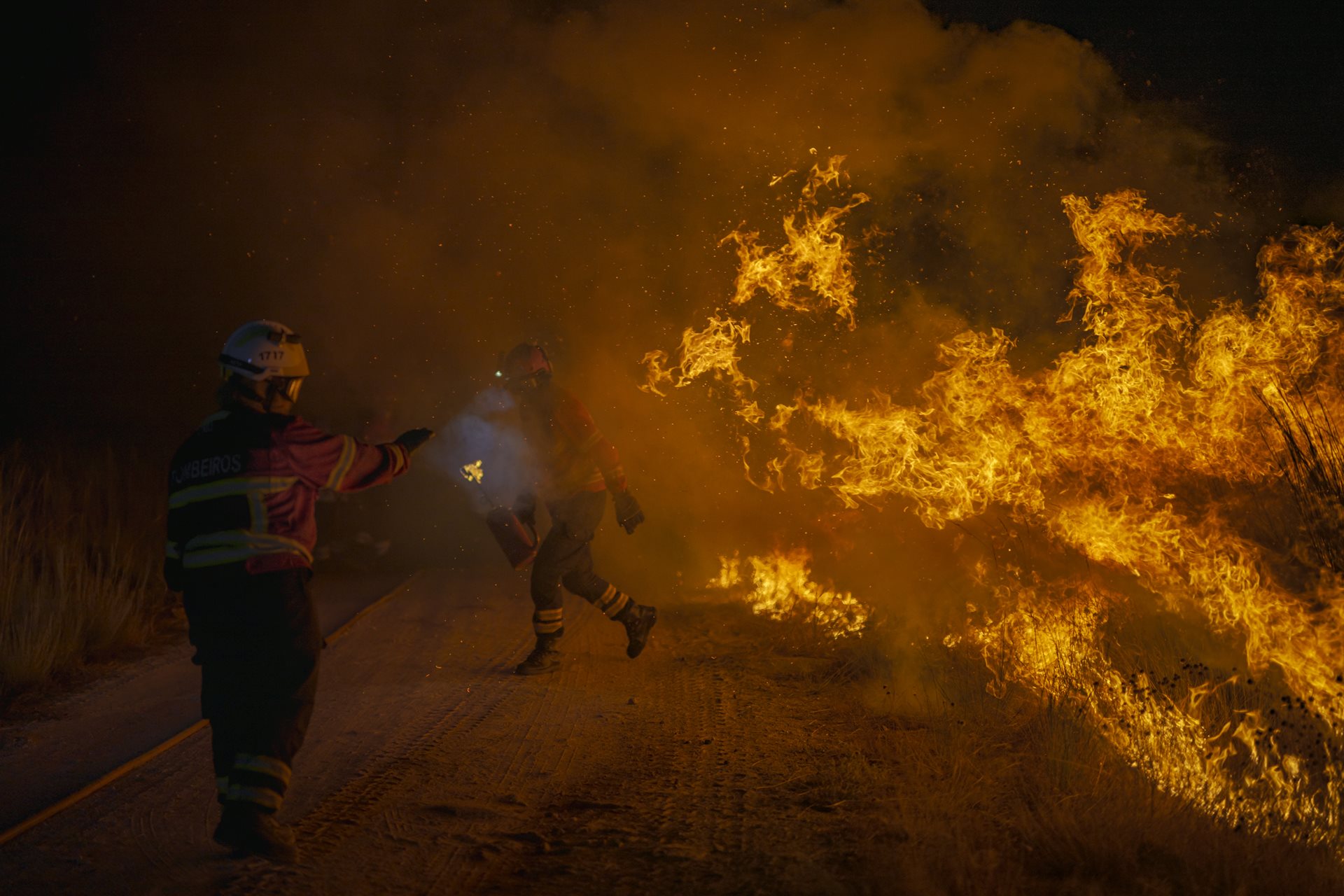 Portuguese firefighters battle a wildfire that started in Cualedro, Ourense, Galicia, Spain, and crossed the border into Portugal.