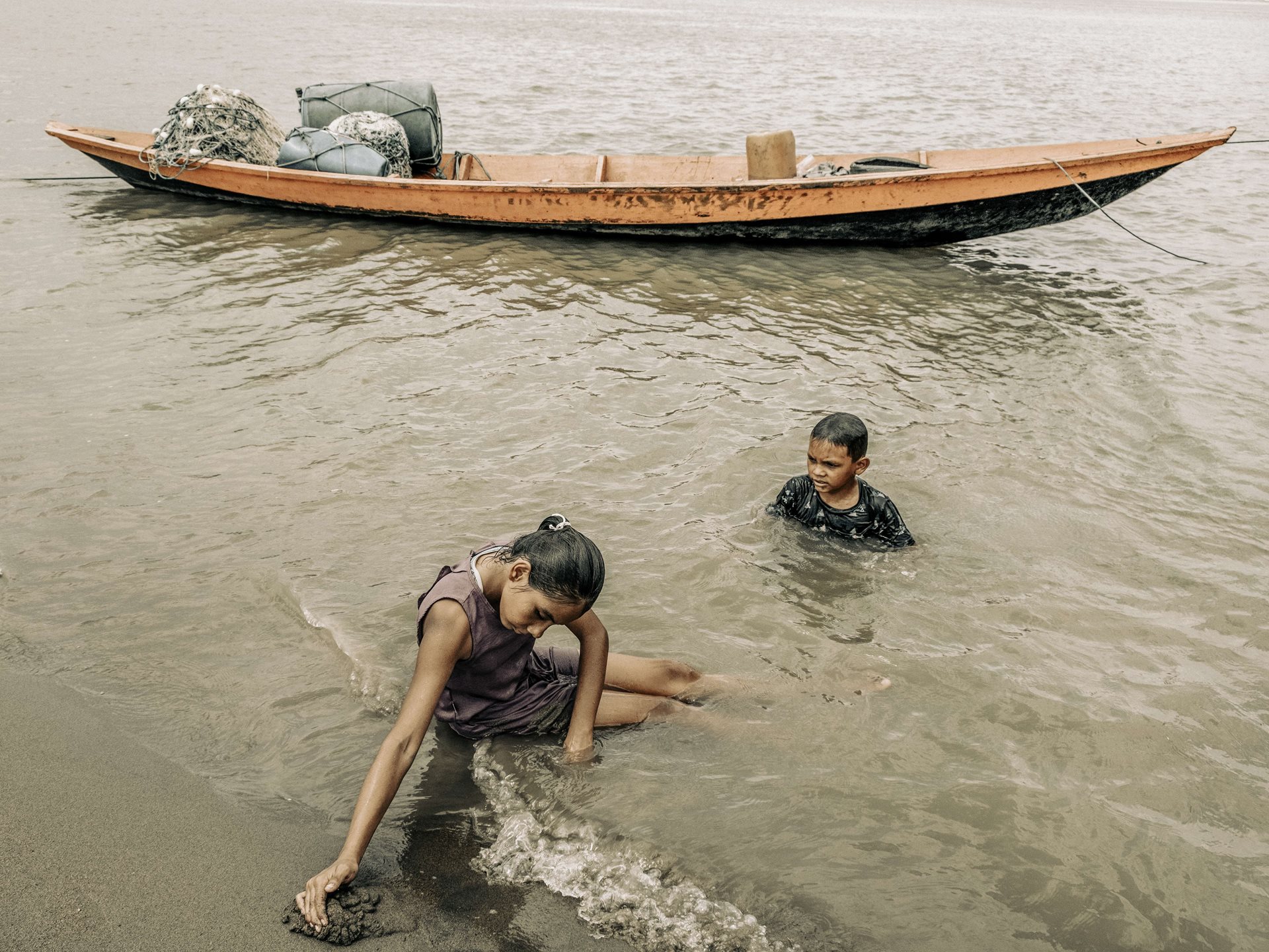 A girl and her brother bathe in the shallows of the Rio Solimões in Manacapuru, Amazonas, Brazil. Under normal conditions, this precise location should be several meters underwater.