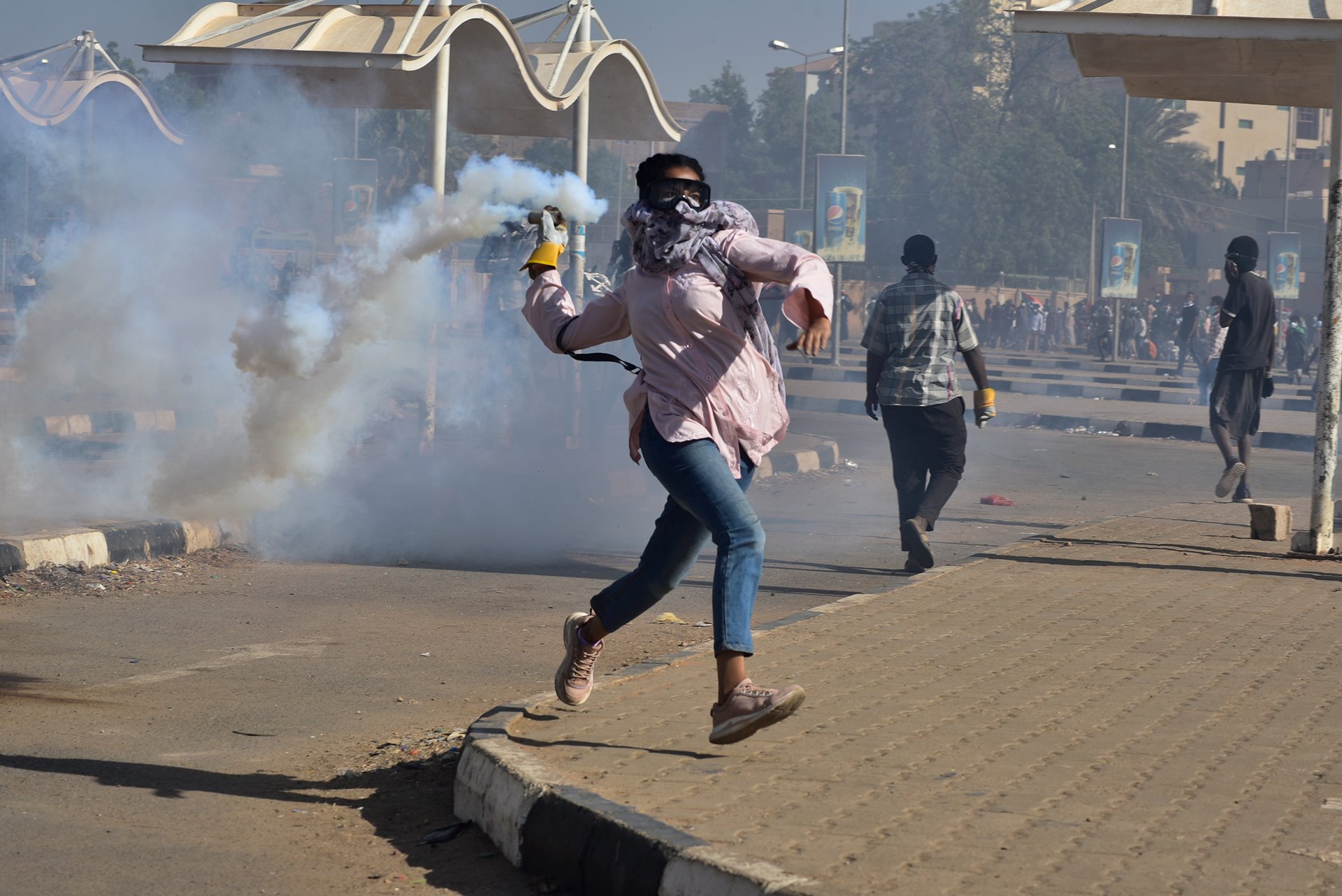 <p>A protester throws back a tear-gas canister that had been fired by security forces, during a march demanding an end to military rule, in Khartoum, Sudan.</p>
