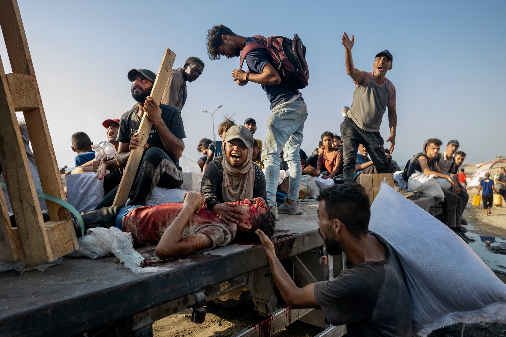 A woman screams for her son who was shot while trying to collect aid from a truck near the Zikim crossing, in the north of Gaza along the coast, and is being rushed to hospital on the same truck. Gaza City, Gaza Strip.