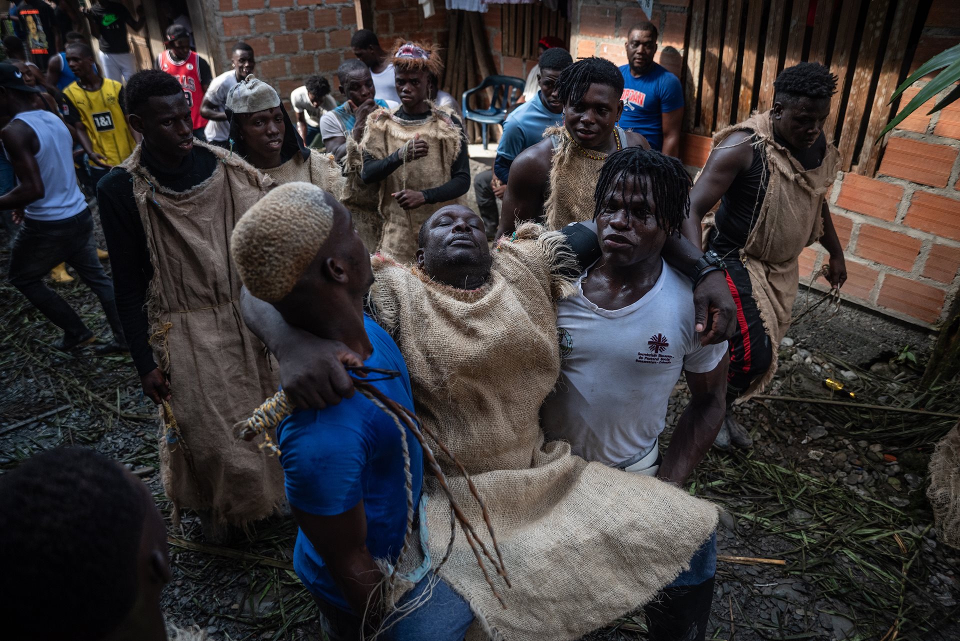 Ariel Angulo (left) and Jair Valencia (right) carry an exhausted Manacillo, Kili &ldquo;Kilinito&rdquo; Rentería in Juntas, Buenaventura, Colombia. Tradition dictates that Manacillos cannot sleep for the first 48 hours of the festival; those who fall asleep are ritualistically whipped.