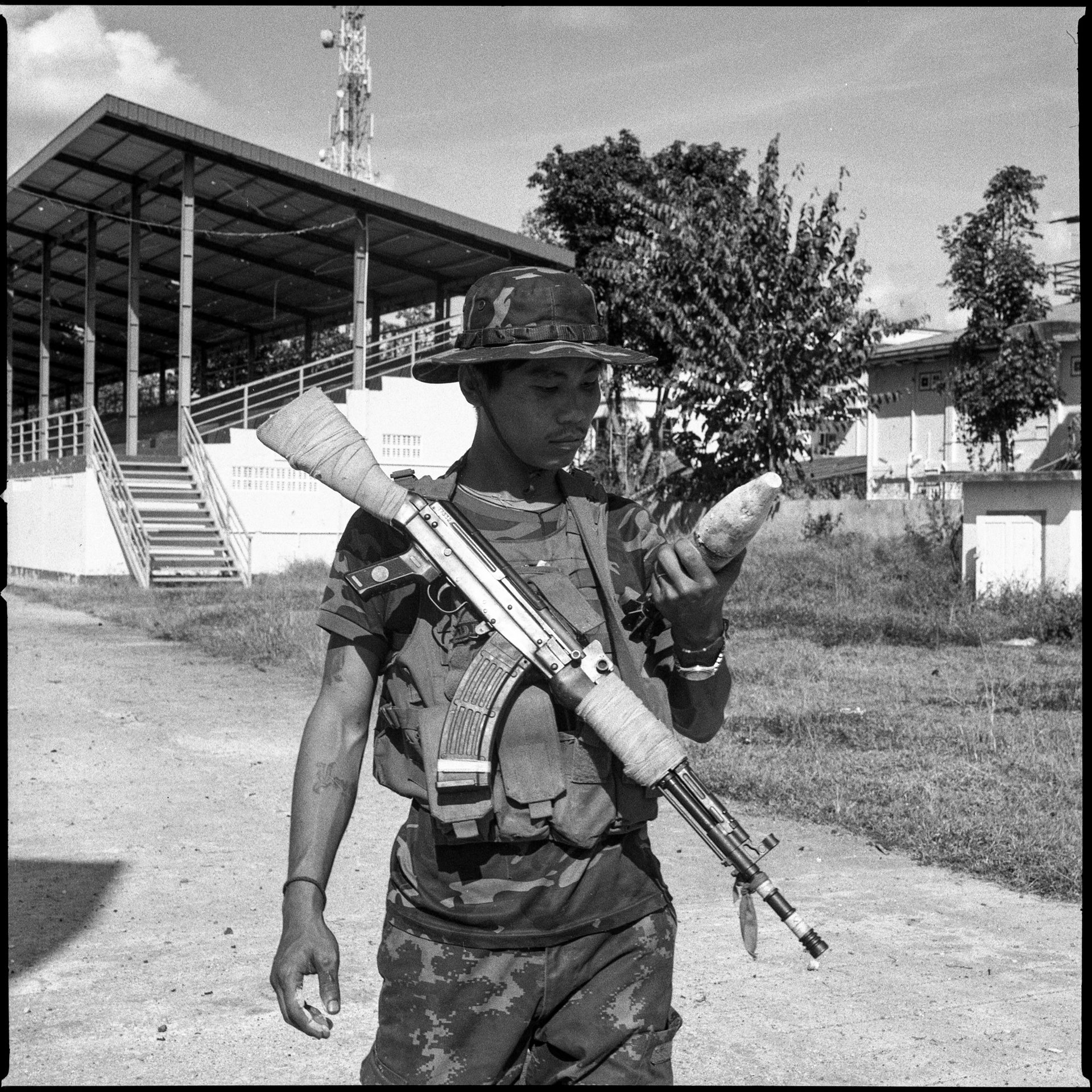 A fighter with the Karenni Nationalities Defense Force (KNDF) examines an unexploded mortar removed from the ground at Loikaw stadium in Kayah (Karenni) State, Myanmar. Fighters reportedly extract gunpowder from unexploded ordnance for reuse in weapons against the Myanmar military.