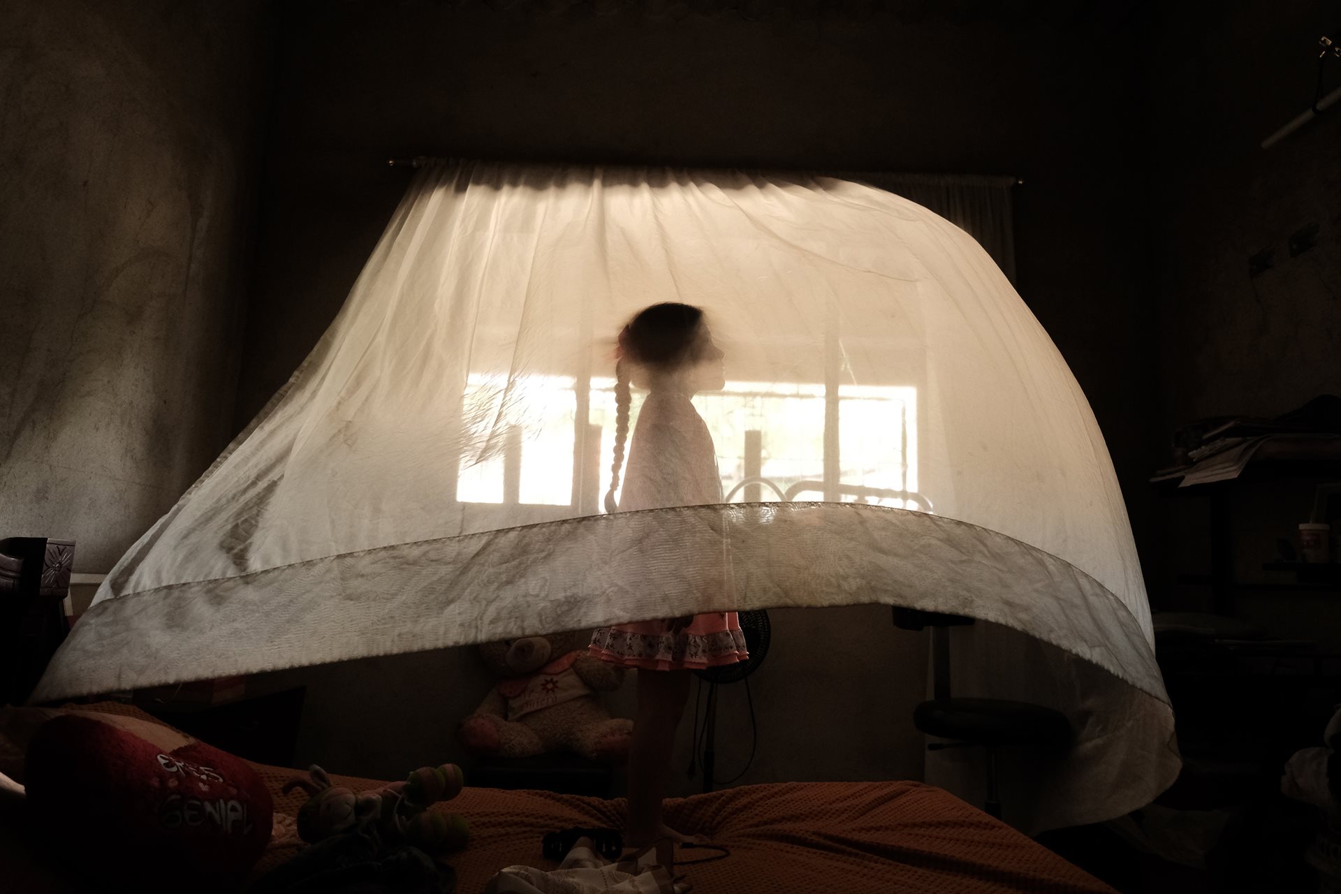 Valeria (5) plays behind a curtain at her aunt&rsquo;s house in Los Patios, Norte de Santander, Colombia. Her mother, Arcenia, is a single mother who commutes to work in Cúcuta. In her region, 30% of households are headed exclusively by women.