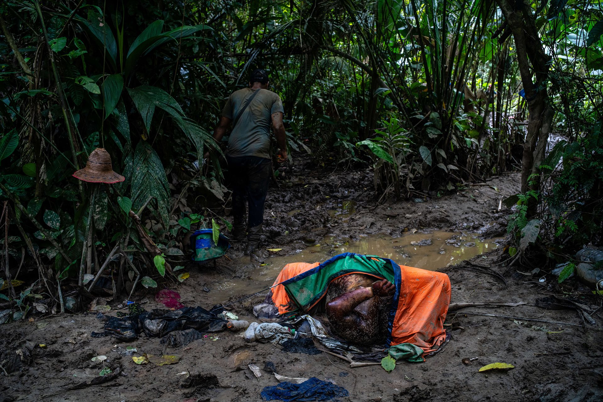 A dead man with his hands and neck tied together lies on the path inside a tent. At least 55 people have died and 180 children abandoned in the Darién in 2024 alone, although estimates of the actual number of deaths are believed to be much higher.