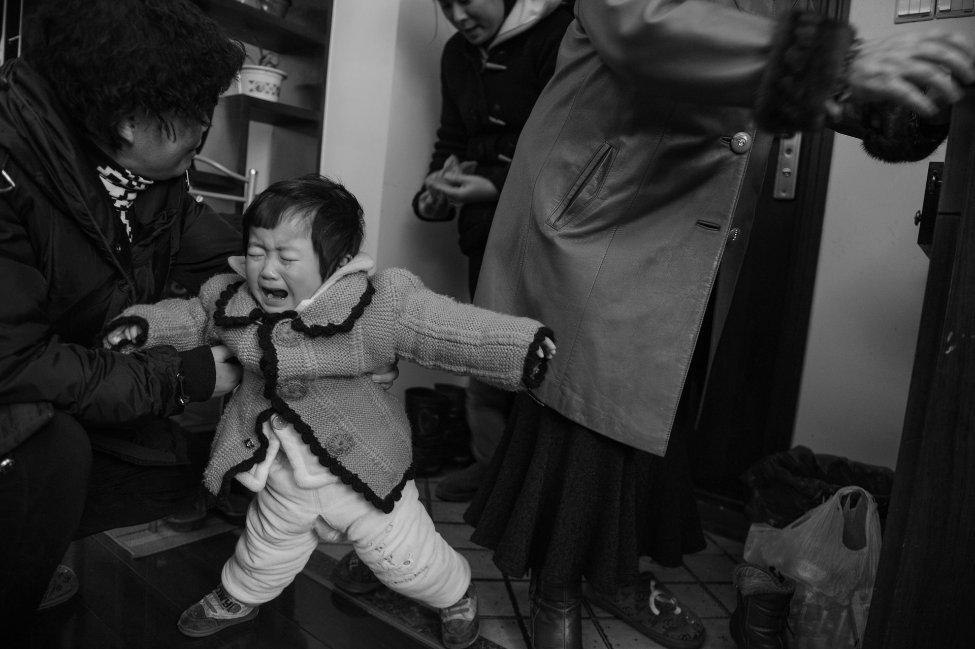 Returning from a work trip, Sheng Hailin is greeted by her daughter, Huihui. To support her young family, the retired doctor went back to work when her daughters were only 100 days old. Hefei, Anhui Province, China.