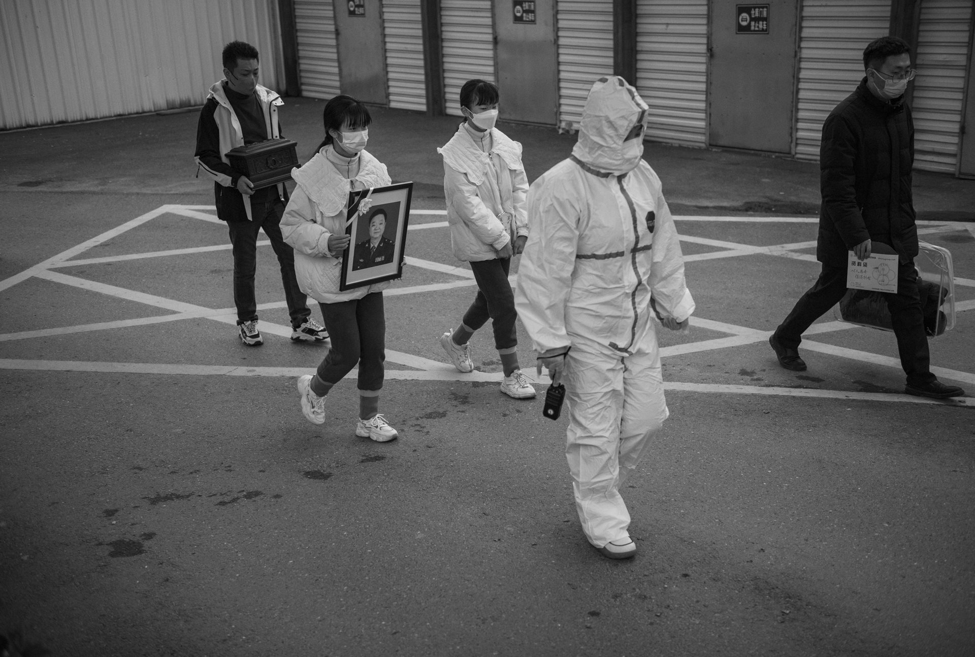 Zhizhi and Huihui carry their father Wu Jingzhou's portrait during his funeral service at the Hefei Funeral Parlor in Hefei, Anhui Province, China. The loss marked a turning point in the photographer's project, shifting the focus to Sheng Hailin as a single mother at 72.