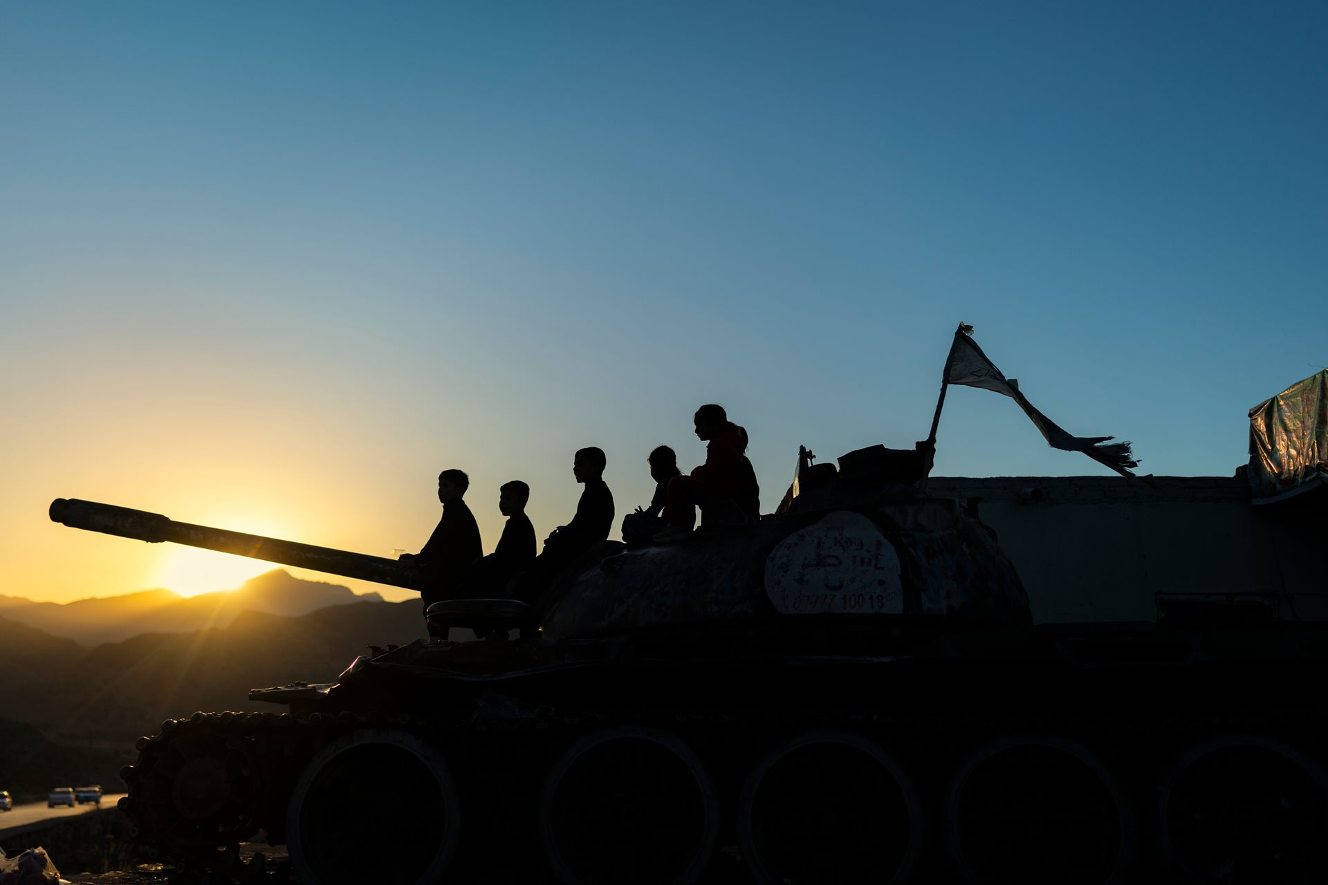 Children play on an abandoned tank used as a landmark on the road between Kabul and Jalalabad in Kabul Province, Afghanistan. Decades of war and worsening teacher shortages since the Taliban's return continue to threaten access to education.