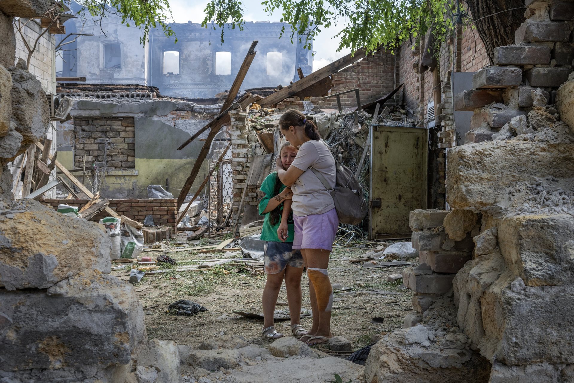 Natalia Harbuznia comforts her daughter Victoria after a swarm of Russian long-range drones attacked their neighborhood, injuring at least 11 people including Natalia. Odesa, Ukraine
