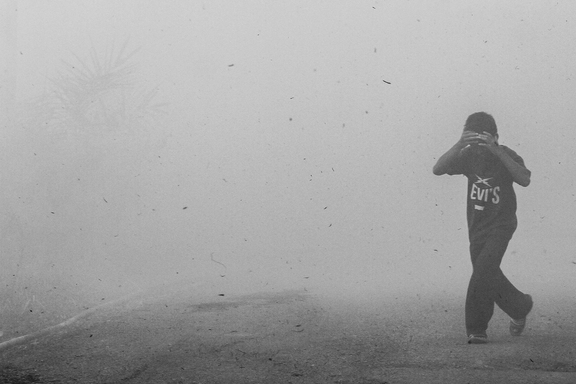 A boy runs from smoke from a peatland fire in the village of Rambutan village, in Ogan Ilir, South Sumatra, Indonesia. Smoke from peatland fires hurts the eyes and makes it difficult to breathe.