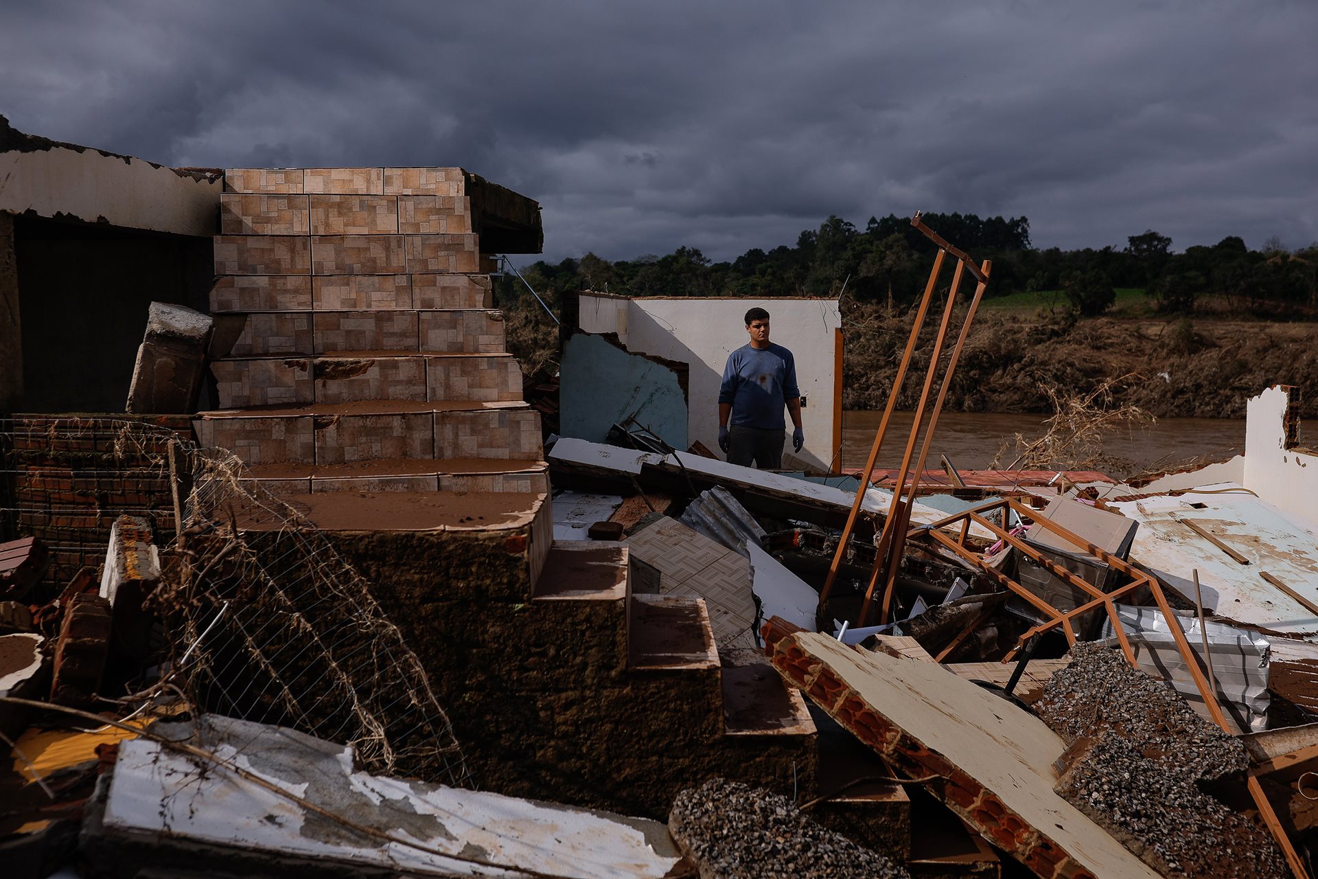 Fernando Wommer (20) stands on the rubble of his relative&rsquo;s house after it was destroyed by the flood. His extended family lived together with their houses standing side by side. Everyone&rsquo;s homes were destroyed. The devastation was so extensive, Fernando&rsquo;s family gave up searching for their belongings. Arroio do Meio, Rio Grande do Sul Brazil.