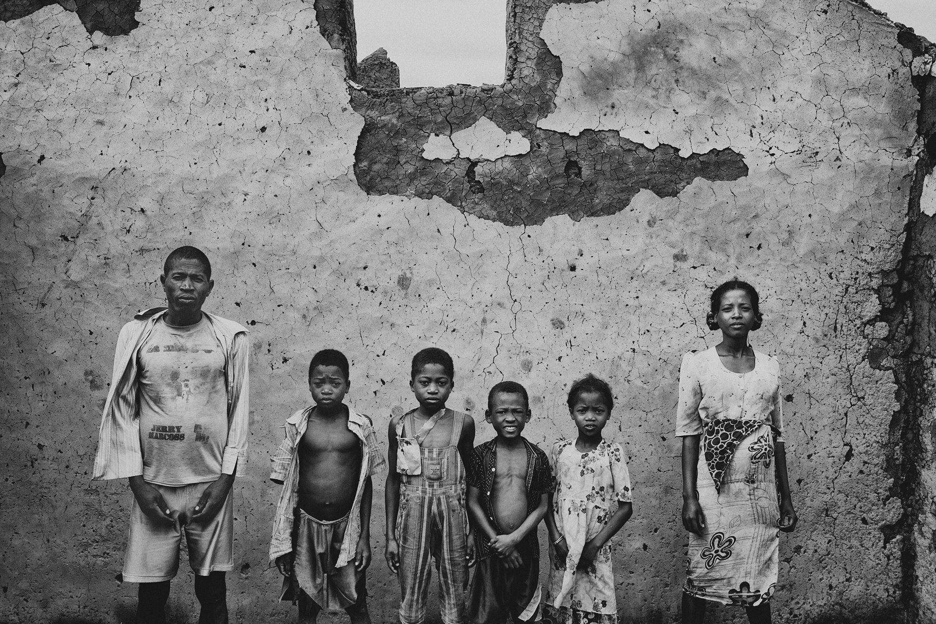 Jean-Baptiste stands with his wife and their children in the ruins of their home, in the village of Andorisa, Andriry, Madagascar. He says they were returning from the rice fields when they saw soldiers burning down their house, and that the soldiers stole a zebu to eat.