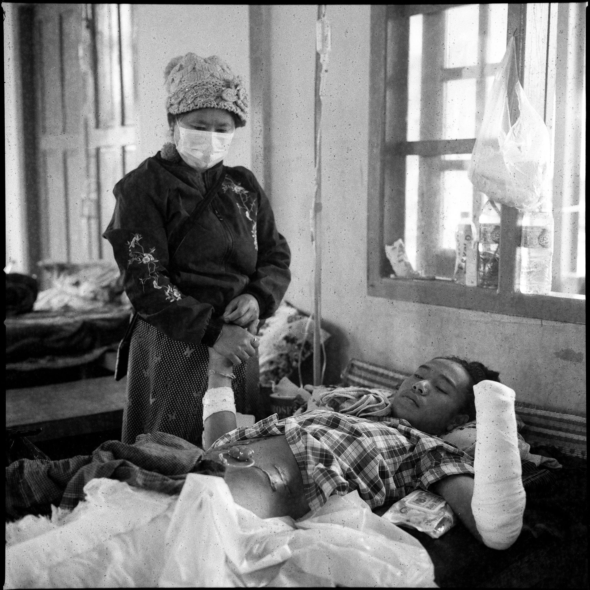 A woman comforts her son after he has had his leg and hands amputated at a hospital in Kayah (Karenni) State, Myanmar.&nbsp;