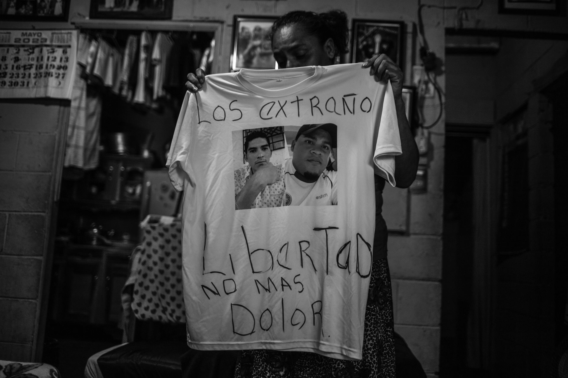 Cecilia Abrego holds a t-shirt with photographs of her sons, who were detained and imprisoned in May 2022. Cecilia has cancer and must find money to send to her sons and for her own treatment. San Salvador, El Salvador.