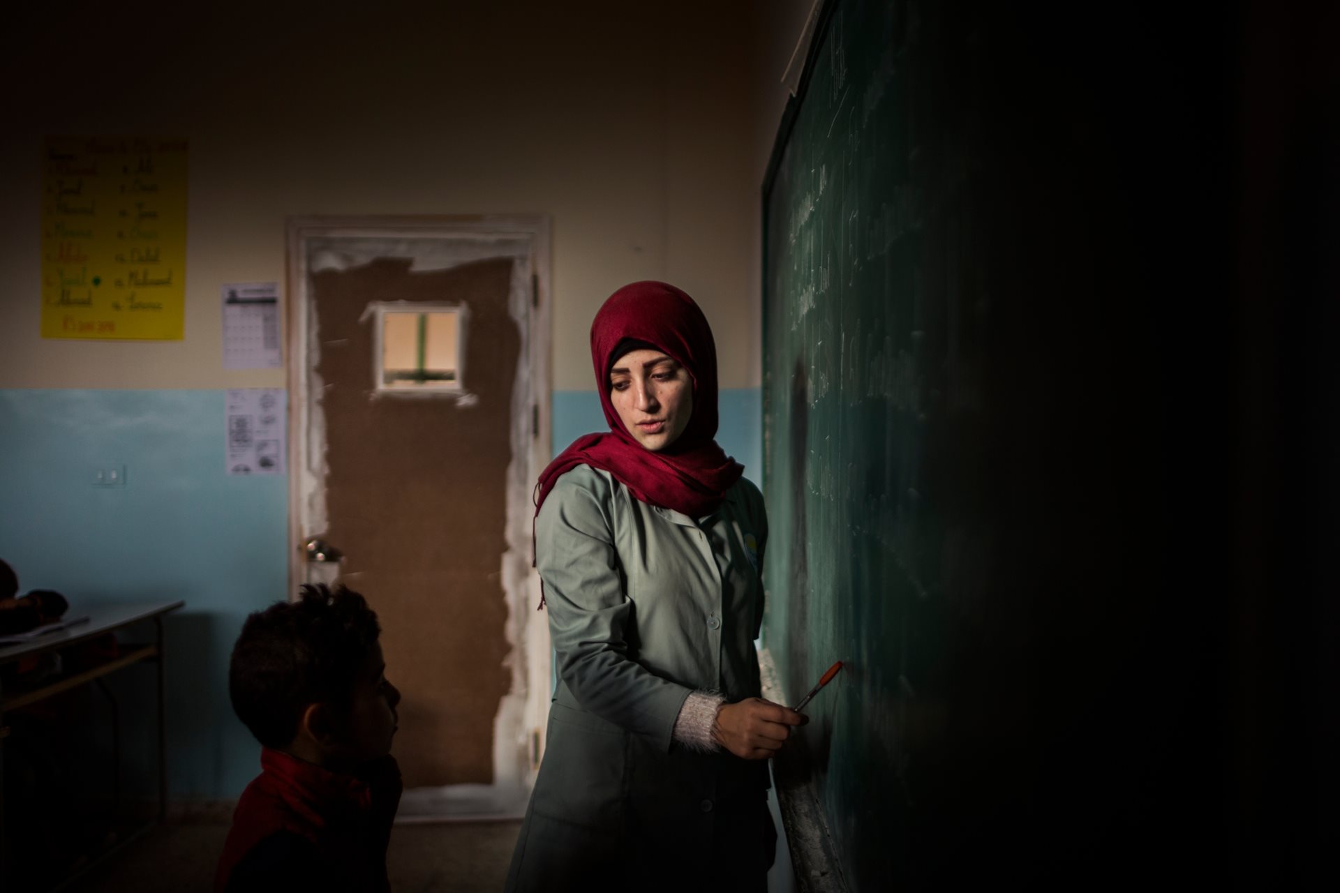 A young Syrian refugee attends a class on the outskirts of Arsal, Lebanon. Limited resources, residency issues, and work restrictions on parents deny many refugee children access to education.