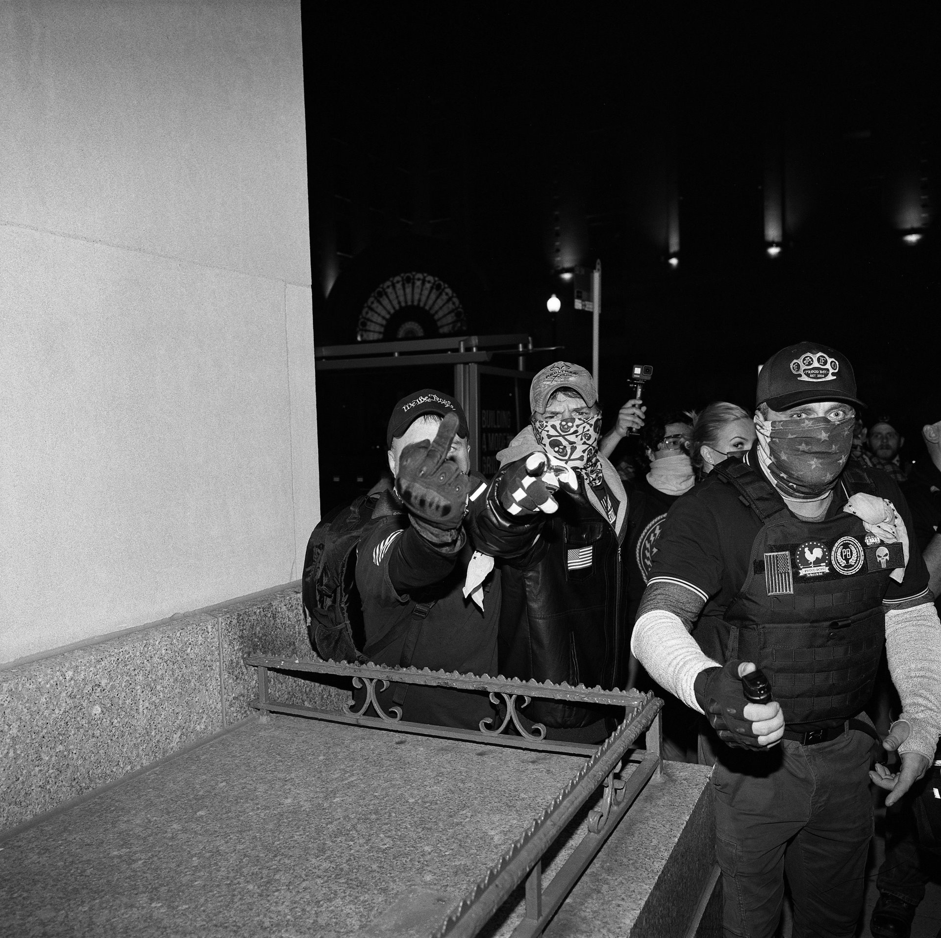 Pro-Trump protesters behind a police line, including one holding a canister of pepper spray, shout death threats at journalists, in a post-election protest in Washington DC, USA. Four people were stabbed, nine hospitalized, and 33 were arrested in the protests. Two post-election protests &ndash; on 14 November and 12 December &ndash; foreshadowed the violence to come on 6 January, when protesters stormed the US Capitol.