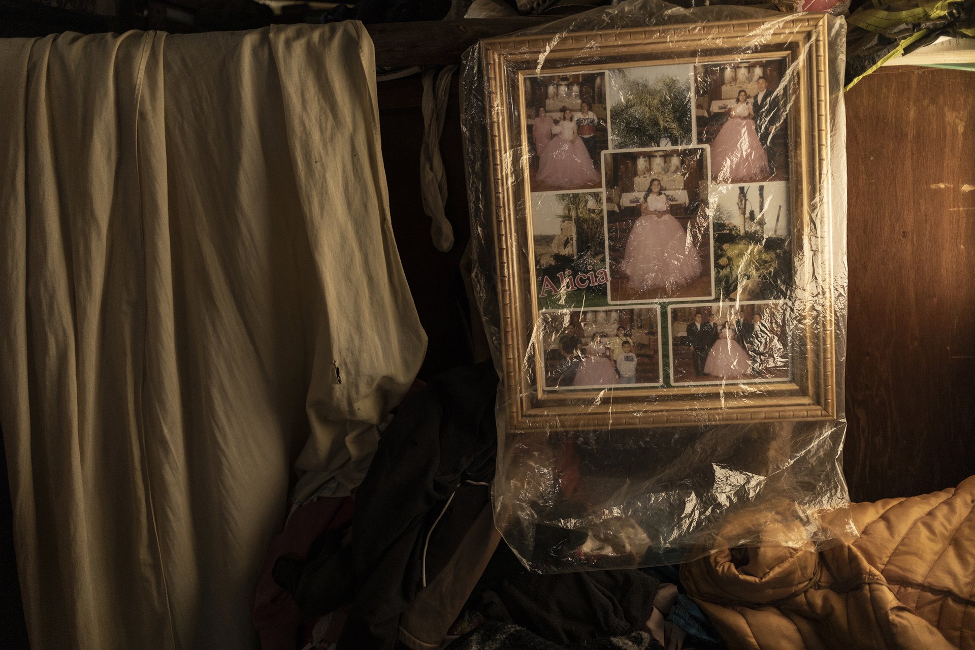 Photographs of Alicia&rsquo;s 15th birthday celebrations stand covered in plastic to keep them clean. Alicia (16) lives with Down syndrome and is looked after by relatives. She shares a house with her mother, who sells tortillas, in the midst of greenhouses in Villa Guerrero, Mexico. A girl&rsquo;s 15th birthday (<em>quinceañera</em>) is significant in Mexican culture as it is said to mark her passage from girlhood to womanhood.