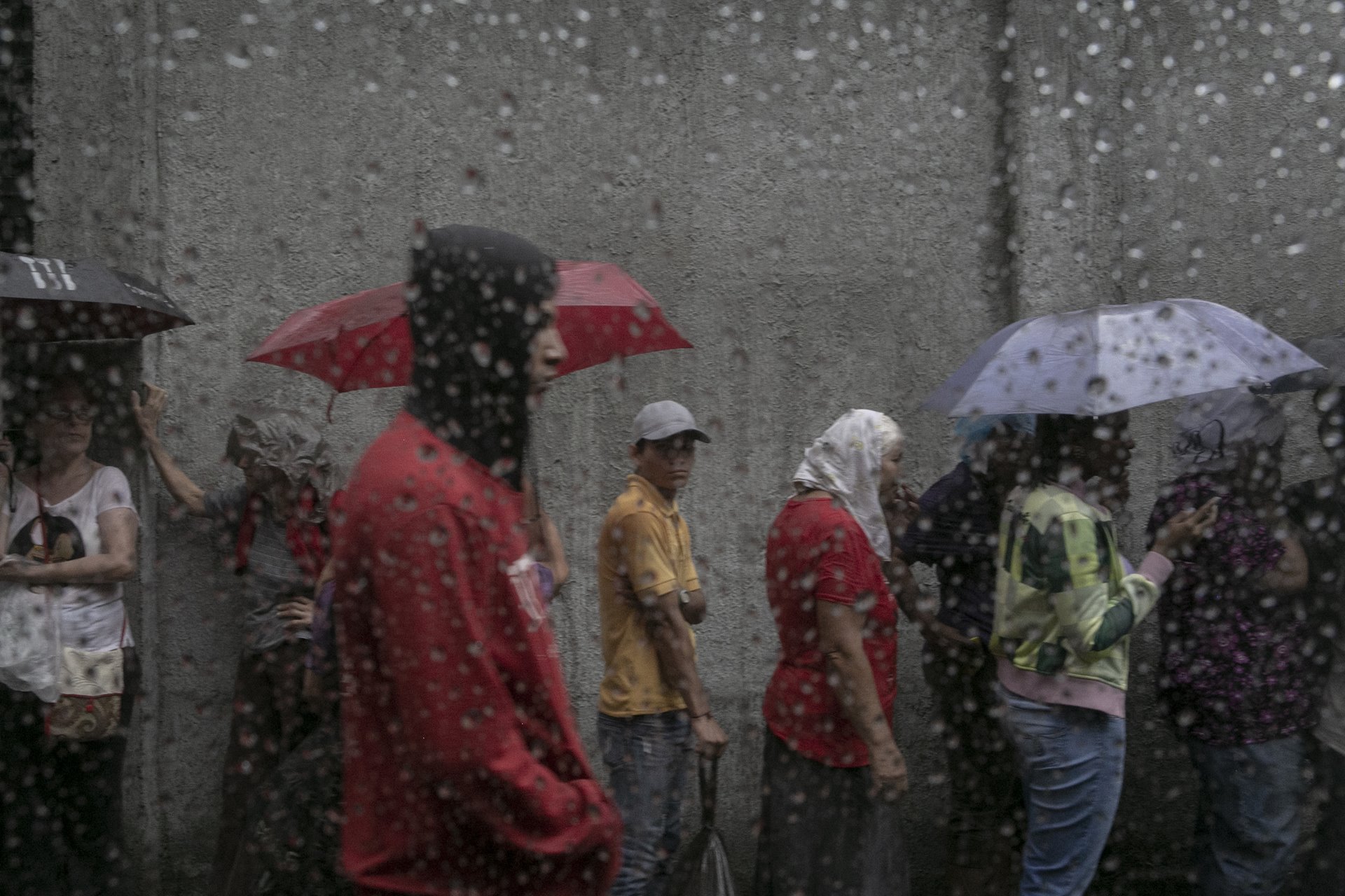 People wait in line to buy their allowance of &nbsp;two bags of rice per person, in Caracas, Venezuela. That morning, people had been lining up since 4am, and were standing in the rain until 11am. Venezuela was experiencing chronic food shortages at the time. In 2016, over 75 percent of Venezuelans said they had lost weight (around eight kilograms on average) due to lack of access to food.