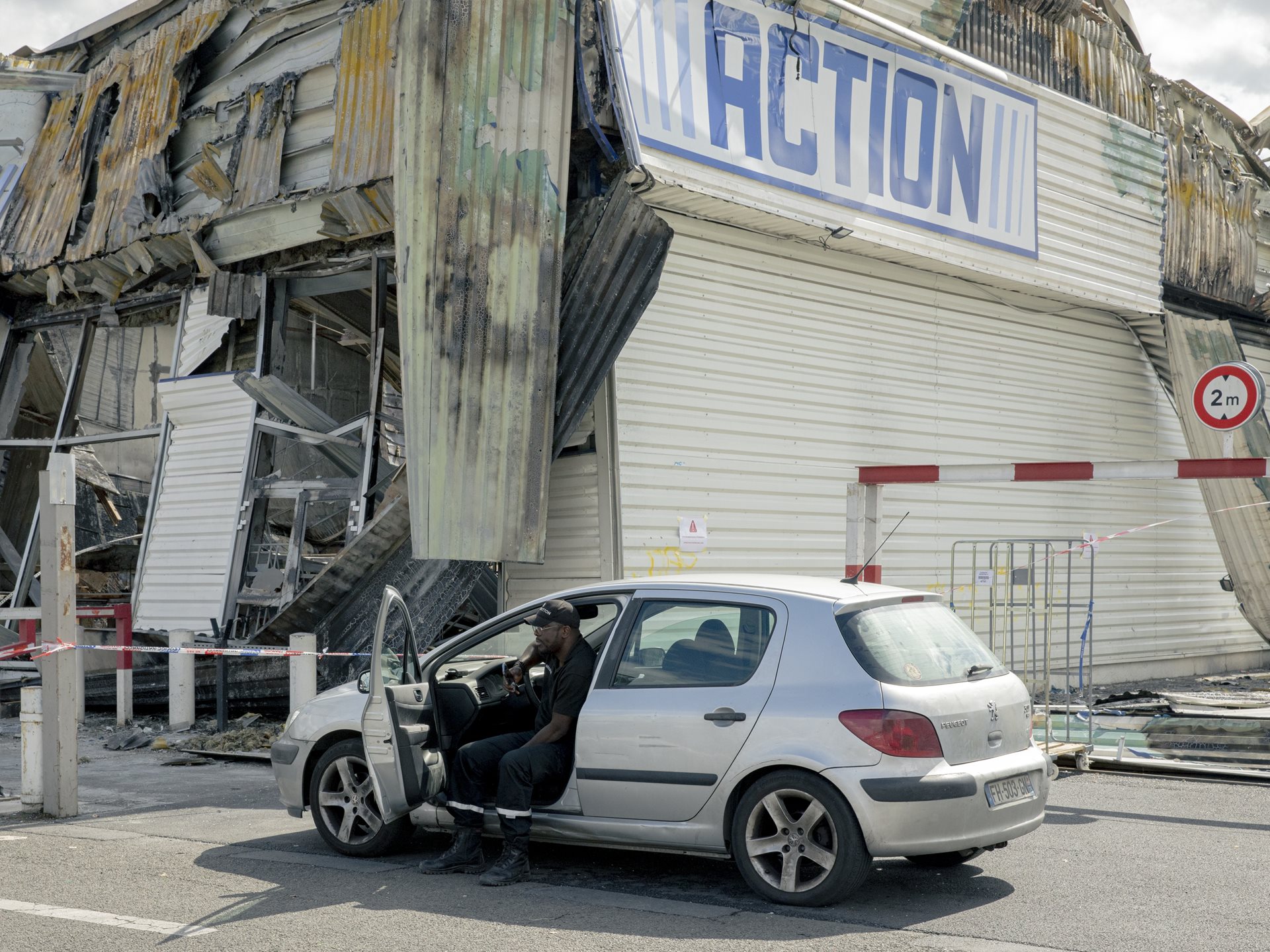 <p>A security guard watches over a burned-out Action discount store in Sevran, France, the day after a night of rioting following the killing of Nahel Merzouk (17), shot by a police officer in Nanterre.&nbsp;</p>
<br />
&nbsp;