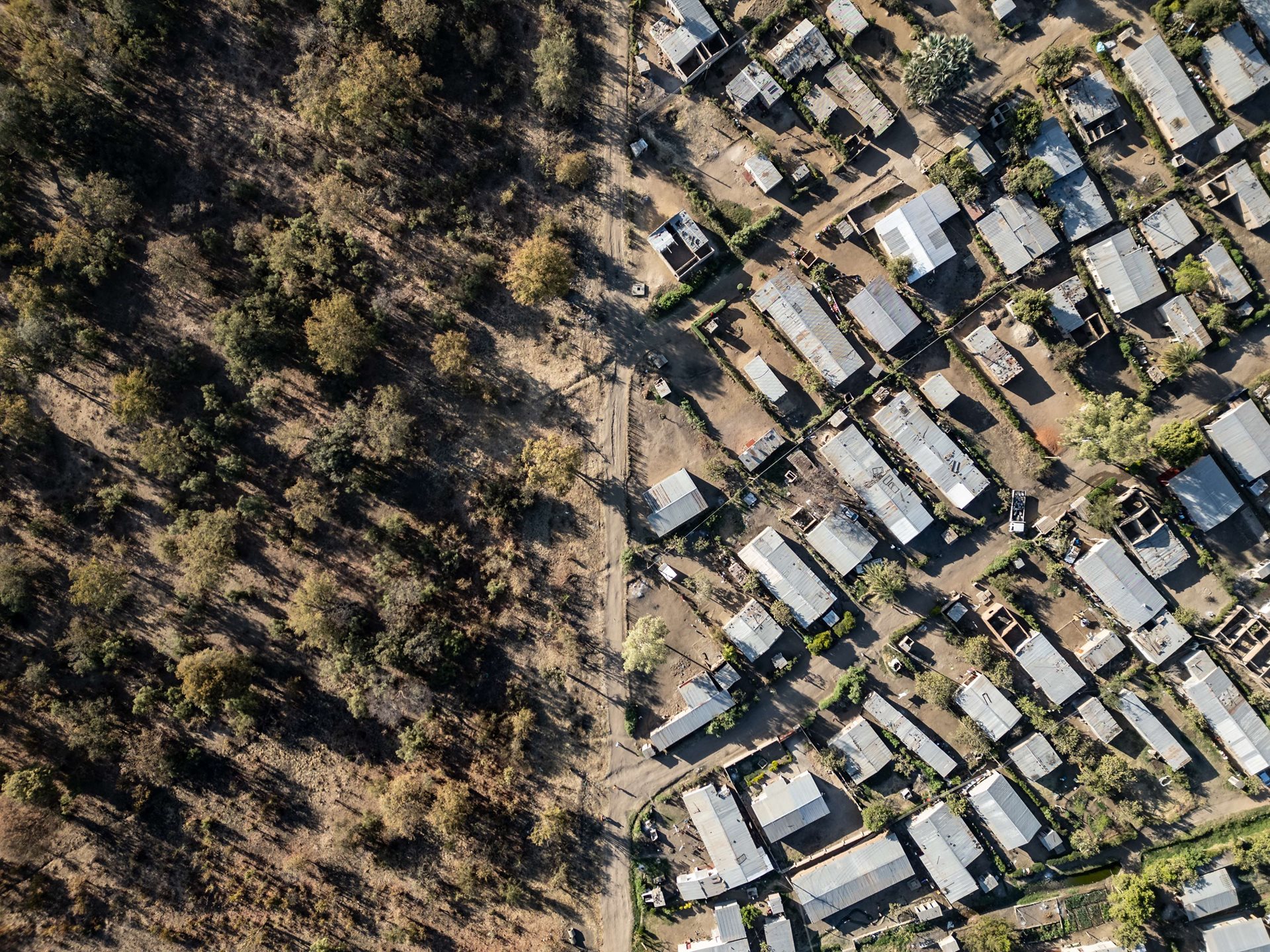 An aerial view of newly constructed homes next to the fence line of Mosi-oa-Tunya National Park shows the rapid expansion of Livingstone, Zambia. The country&rsquo;s population has nearly tripled since 1990.