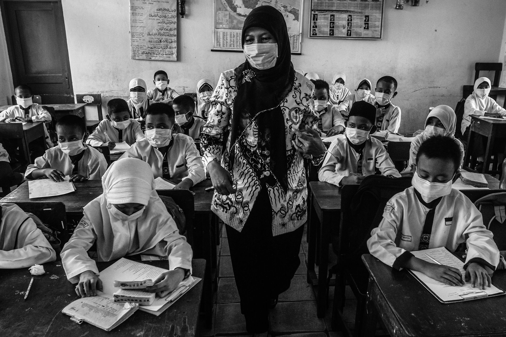 A teacher and her students all wear face masks to protect themselves against toxic haze from wildfires, in Palembang, South Sumatra, Indonesia.