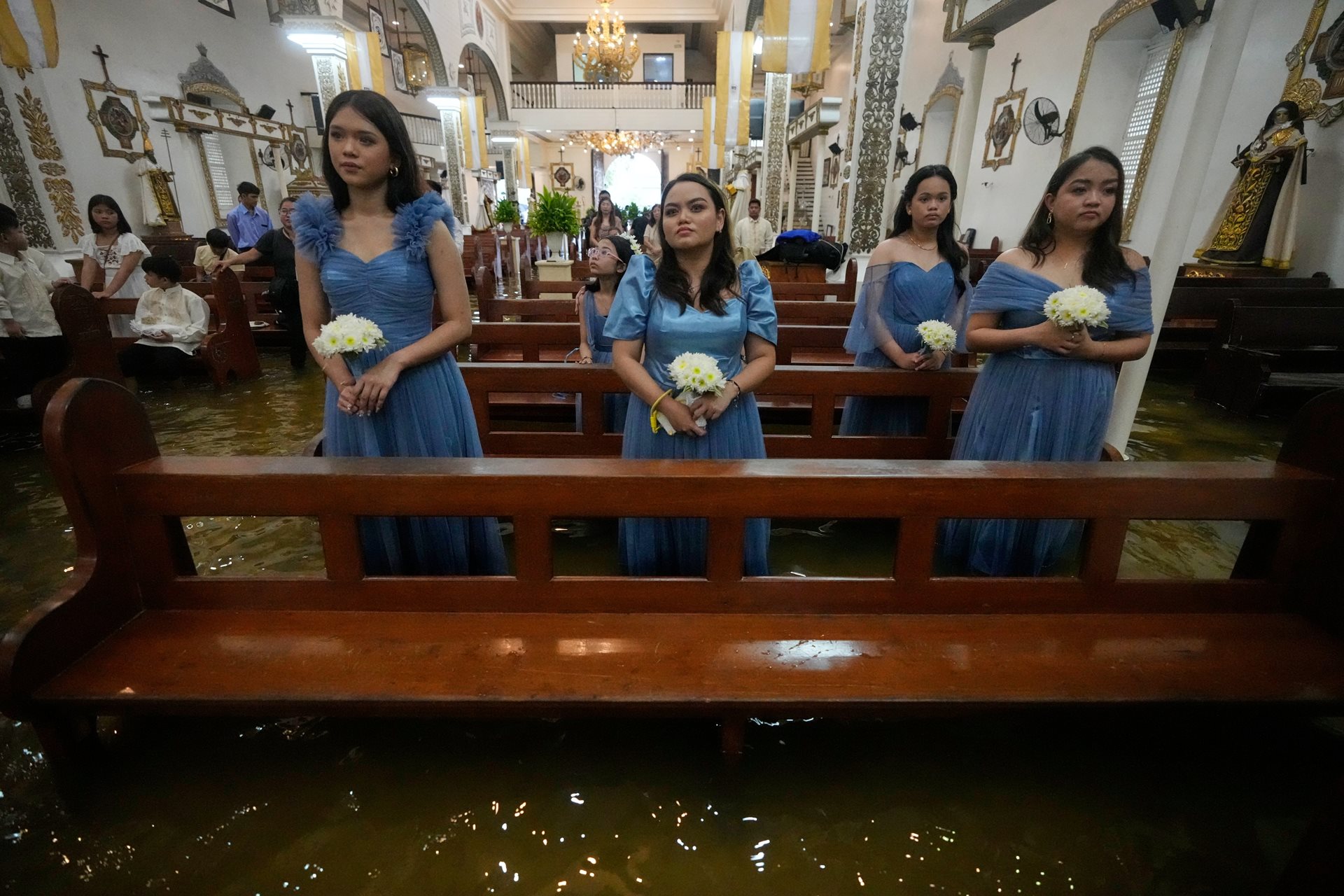 Bridesmaids stand in the flooded Barasoain Church in Malolos, Bulacan province, Philippines. Known as the &ldquo;Cradle of Democracy in the East,&rdquo; the church was the site of the 1898 congress that ratified the first Philippine Constitution.