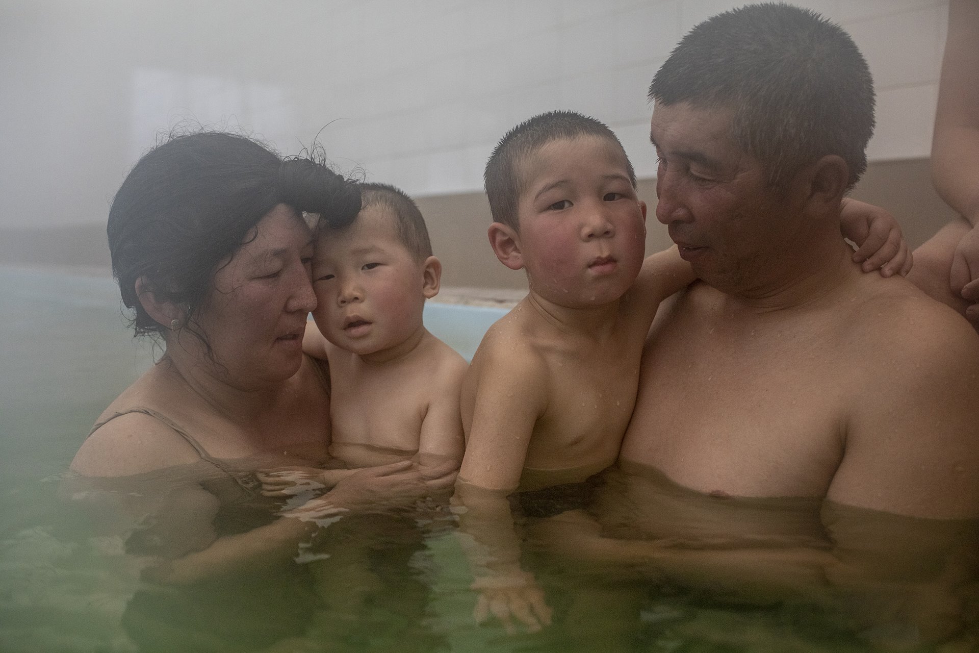 <p>Jaynagul Brjieva (37) and her family (from left to right) Adakhan (2), &nbsp;Alikhan (3), and Nurlan Bayduev (41) enjoy an outing to a hot spring in Kaji-Say, Kyrgyzstan. The waters are thought by some to have healing properties.</p>
