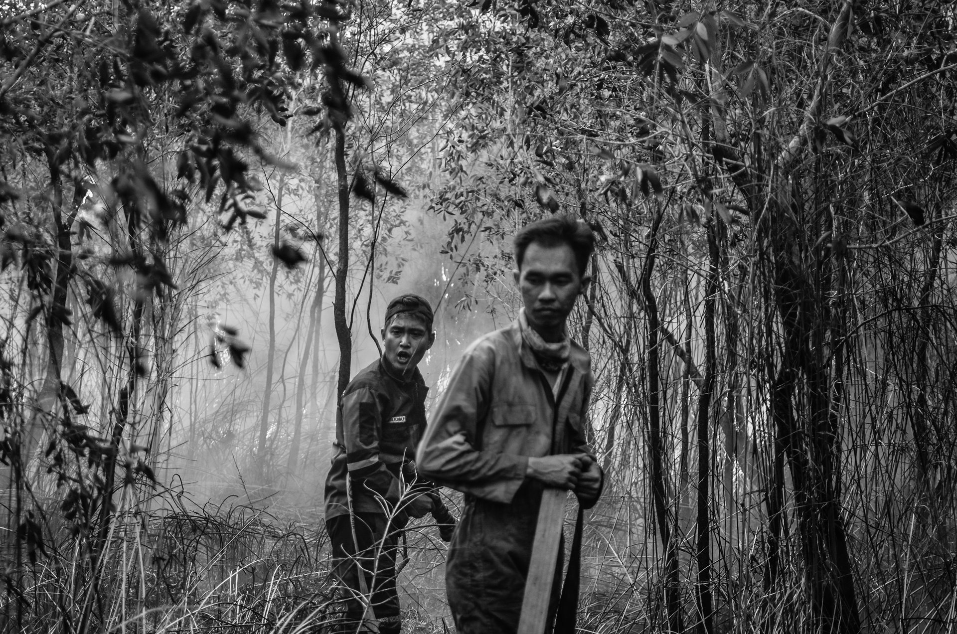 A firefighter shouts to a colleague for water to extinguish a peat fire in Arisan Jaya, South Sumatra, Indonesia. Burning peatlands are difficult to extinguish, and, in the dry season, water was difficult to obtain.