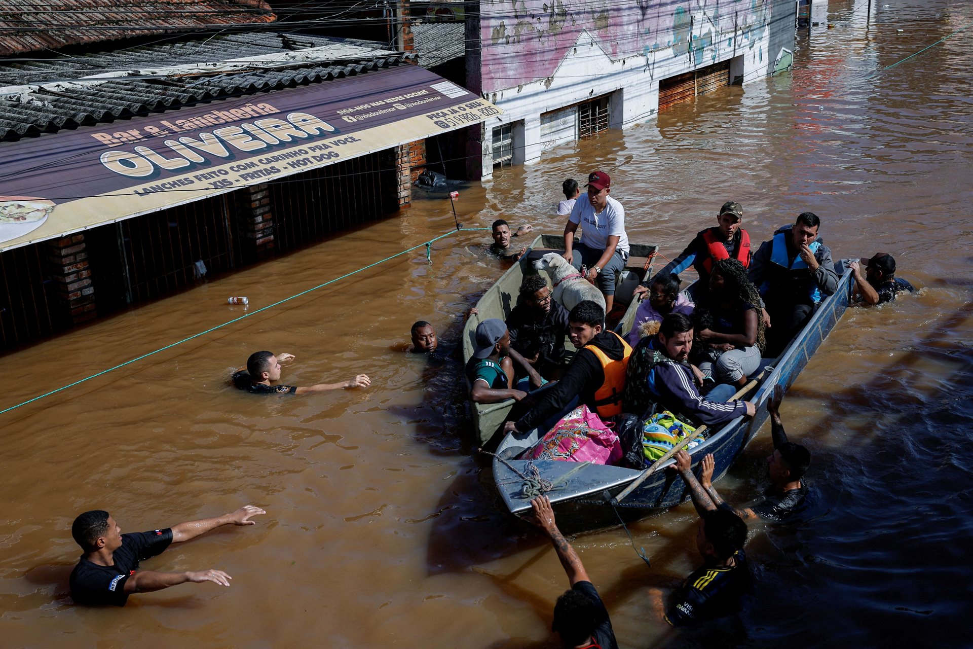 Volunteers use their own boats to rescue people trapped by rising floodwaters, in Canoas, Rio Grande do Sul, Brazil. Emergency teams and local volunteers navigated strong currents to evacuate families and pets to safety.