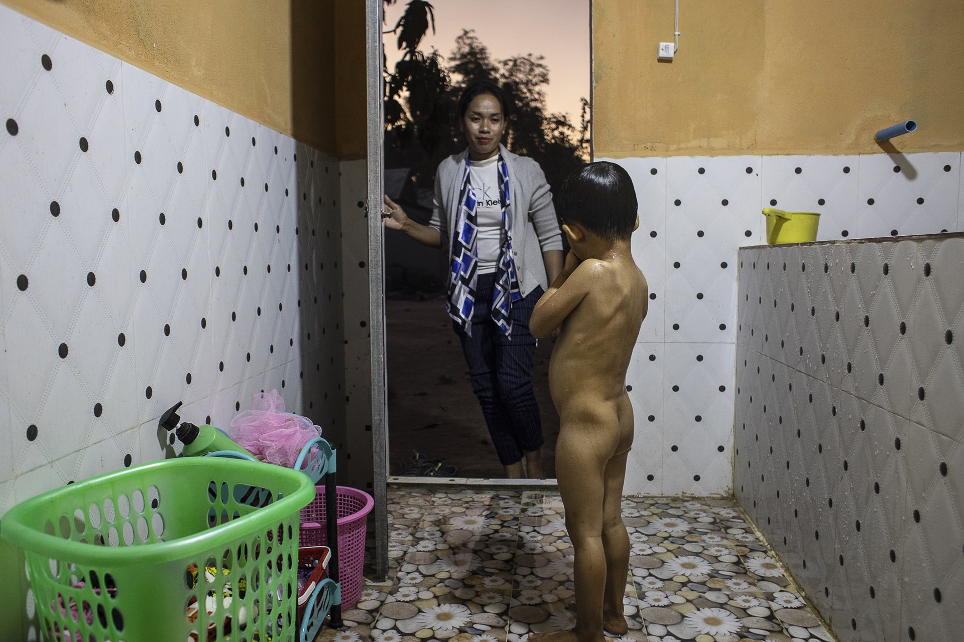 Ry Ly bathes her surrogate son Korng (3) at her home in Kampong Speu, Cambodia.&nbsp;