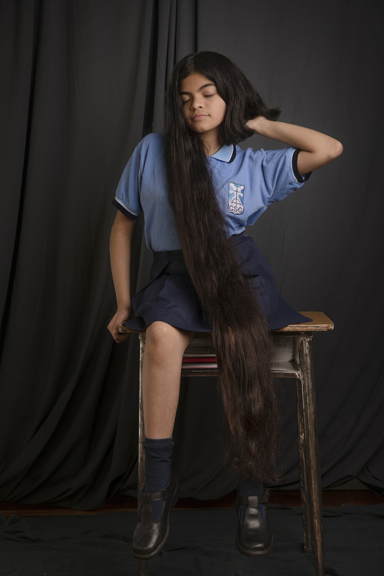 Antonella poses for a portrait after half her hair has been cut, in Buenos Aires, Argentina. Antonella had her hair cut the weekend before she at last returned to full in-person classes after lockdown. Her parents created a small stage with a black backdrop for the occasion.&nbsp;