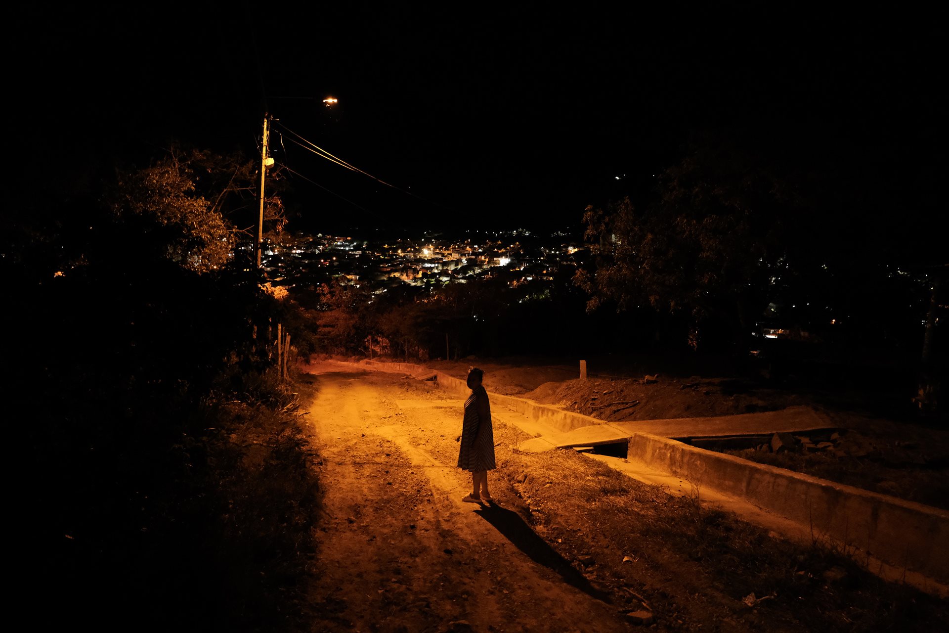 The photographer's mother, Carmen (50), waits on a street in Los Patios, Norte de Santander, Colombia. Since her husband&rsquo;s murder in 1999, she has raised her only son alone, moving multiple times across Colombia to escape persistent violence.&nbsp;