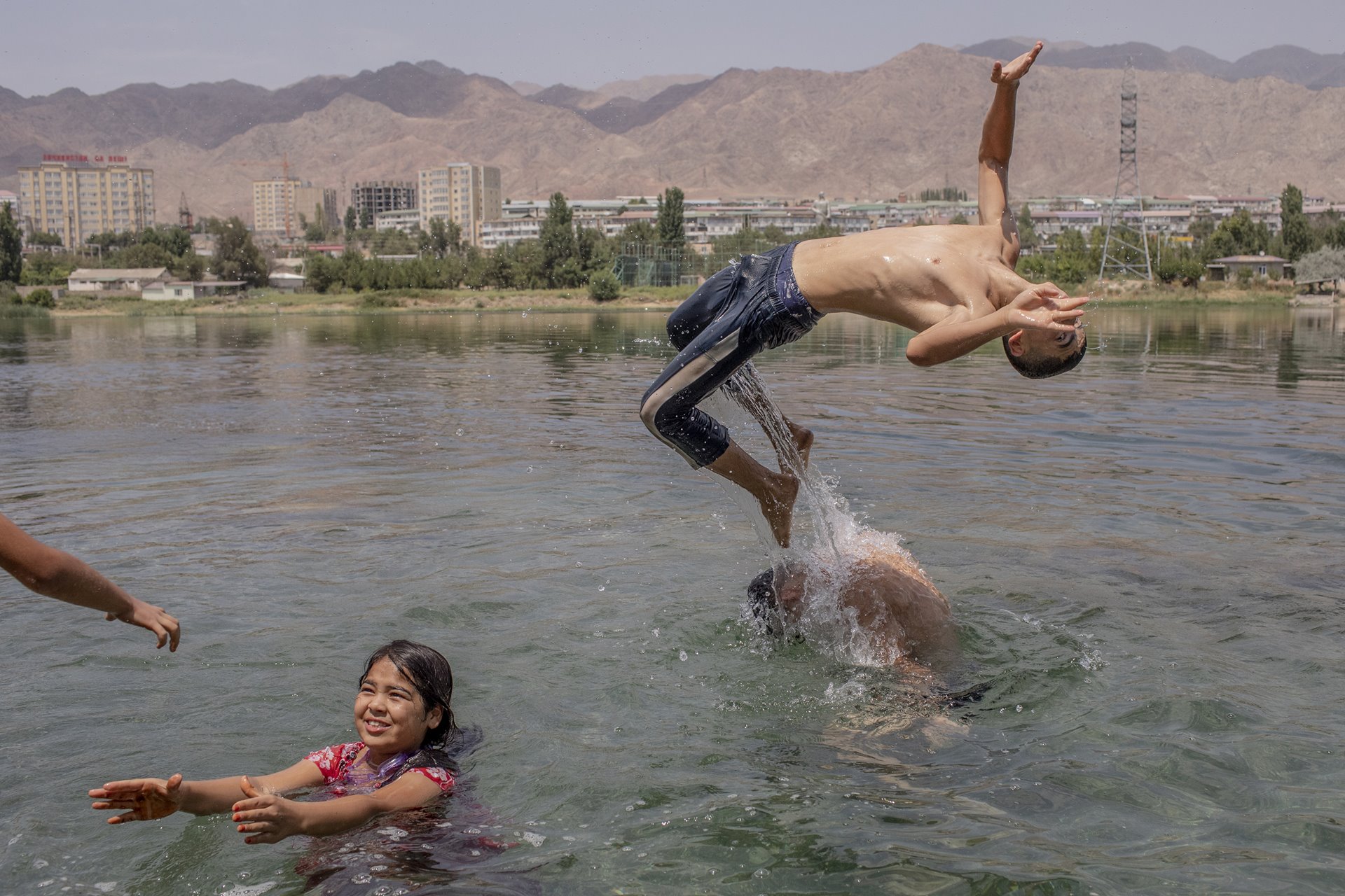 Young people swim in the Syr Darya River, where it flows through Khujand, Tajikistan&rsquo;s second-largest city.