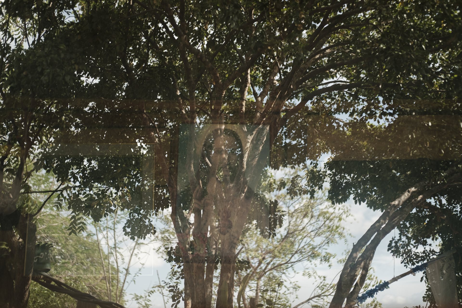 A painting of Jesus Christ is reflected by the window in Los Patios, Norte de Santander, Colombia. Placed by the photographer&rsquo;s late grandfather, it is the sole male presence remaining inside grandmother Orfelina&rsquo;s home.