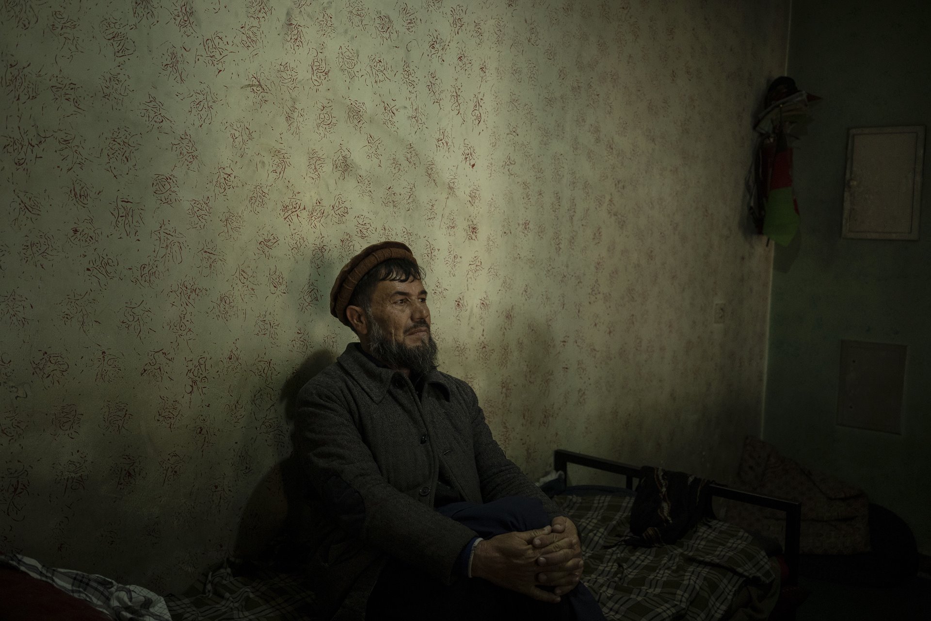 Abdul Fatah sits on his bed inside the Ariana Cinema, in Kabul, Afghanistan. Fatah lives in the cinema, where he works as a security guard.