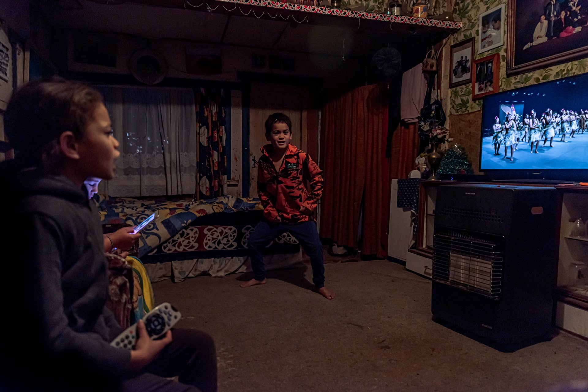 Children of the Teepa family watch one of their older cousins perform in a secondary schools&rsquo; kapa haka competition on Māori TV, at their grandparents&rsquo; homestead, in Ruatoki, New Zealand. Kapa haka, a traditional performing art, combines singing in Te Reo Māori, dancing, and rhythmic movements, and such events allow Māori youth to connect with their cultural heritage.