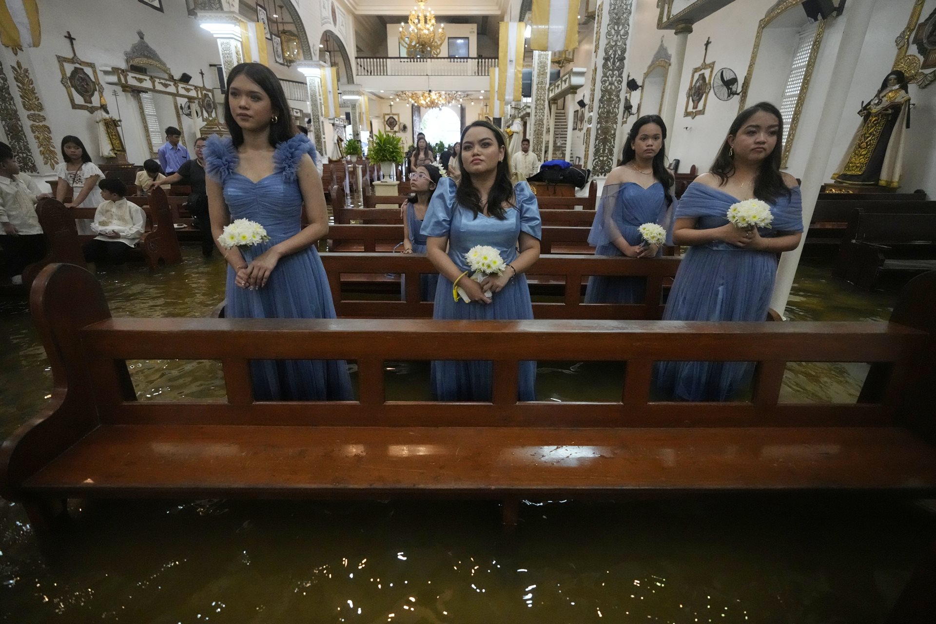 Bridesmaids stand in the flooded Barasoain Church in Malolos, Bulacan province, Philippines. Known as the &ldquo;Cradle of Democracy in the East,&rdquo; the church was the site of the 1898 congress that ratified the first Philippine Constitution.