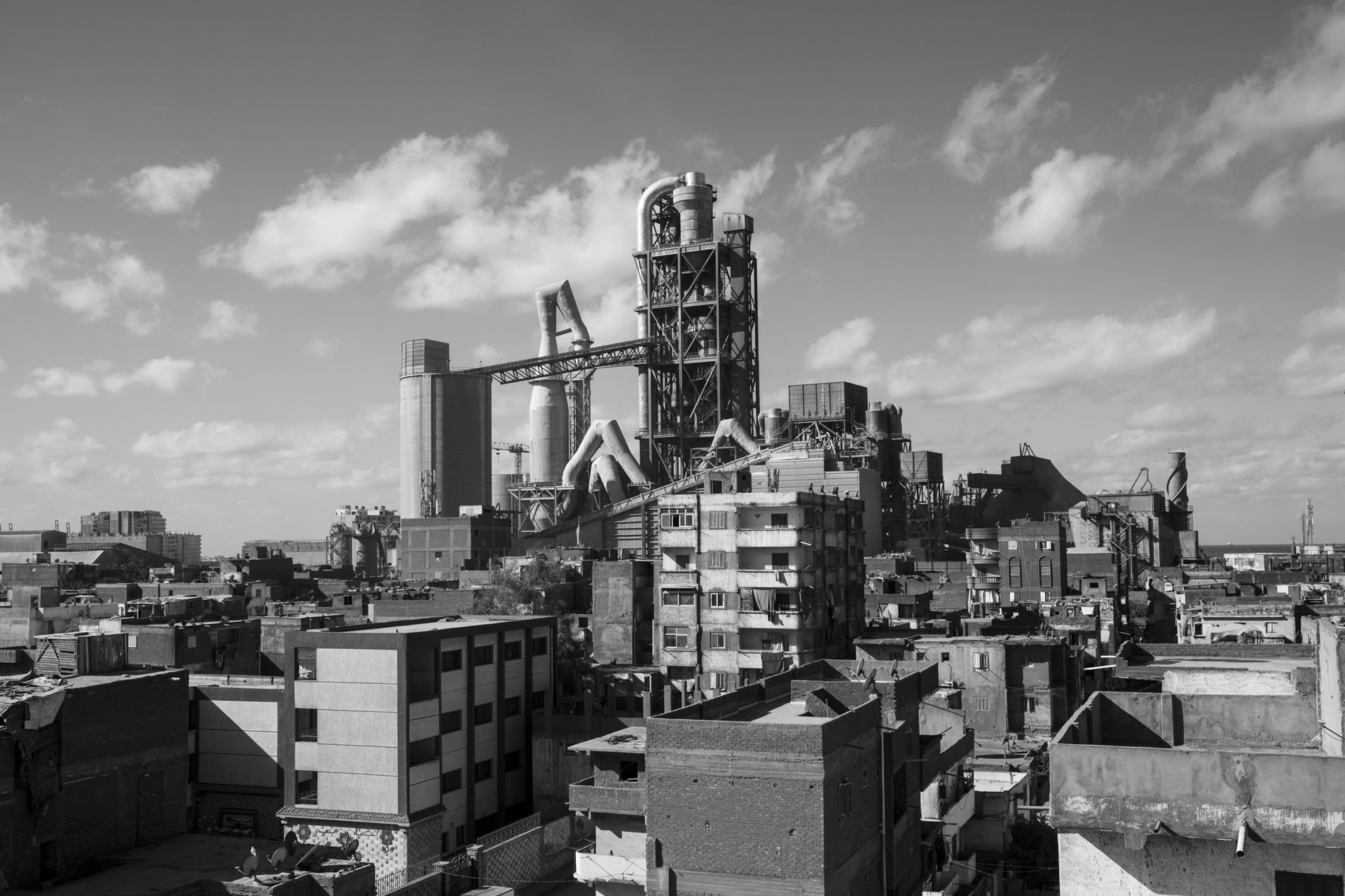 The Titan cement factory, also known as the Fifth Oven, was constructed adjacent to the northern edge of the residential area of Moon Valley in Alexandria, Egypt. Prevailing northwestern winds carry dust, coal, and waste directly into homes.