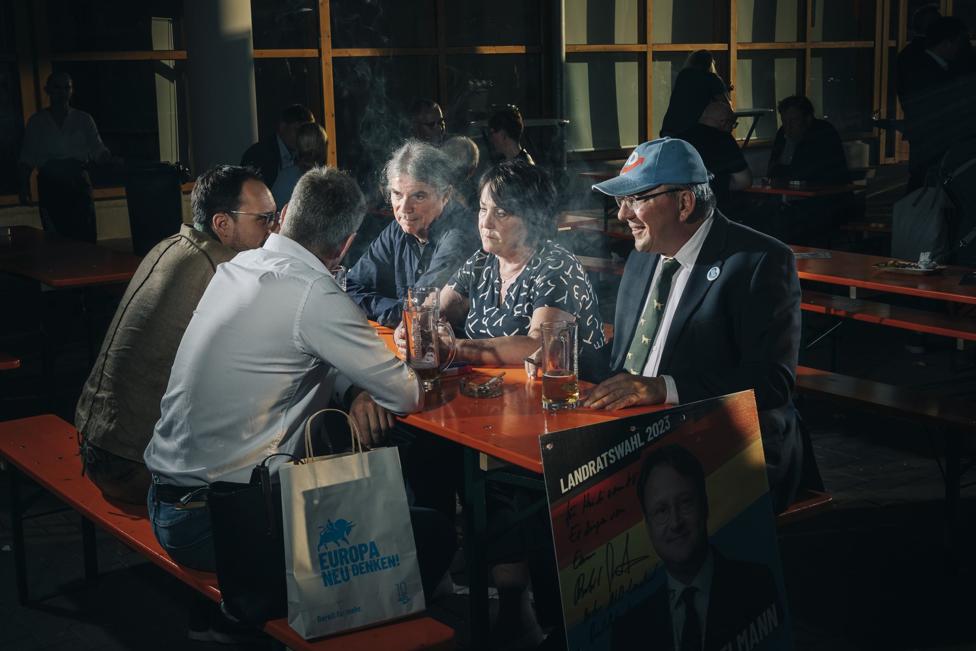Party members, including AfD deputy district chairman Peter Junker (in blue cap), socialize at a party conference in Magdeburg, Germany. Junker was convicted of incitement to hatred after an anti-LGBTQI+ speech at the convention.