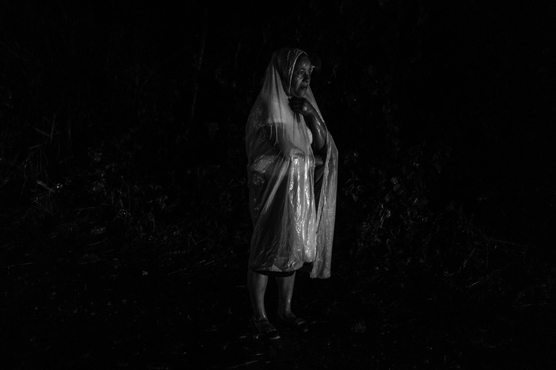 Noelys González stands in the rain on the street that leads to the Izalco prison. She is looking for her brother, who was arrested several weeks earlier in Juayúa, Sonsonate. Izalco, El Salvador.